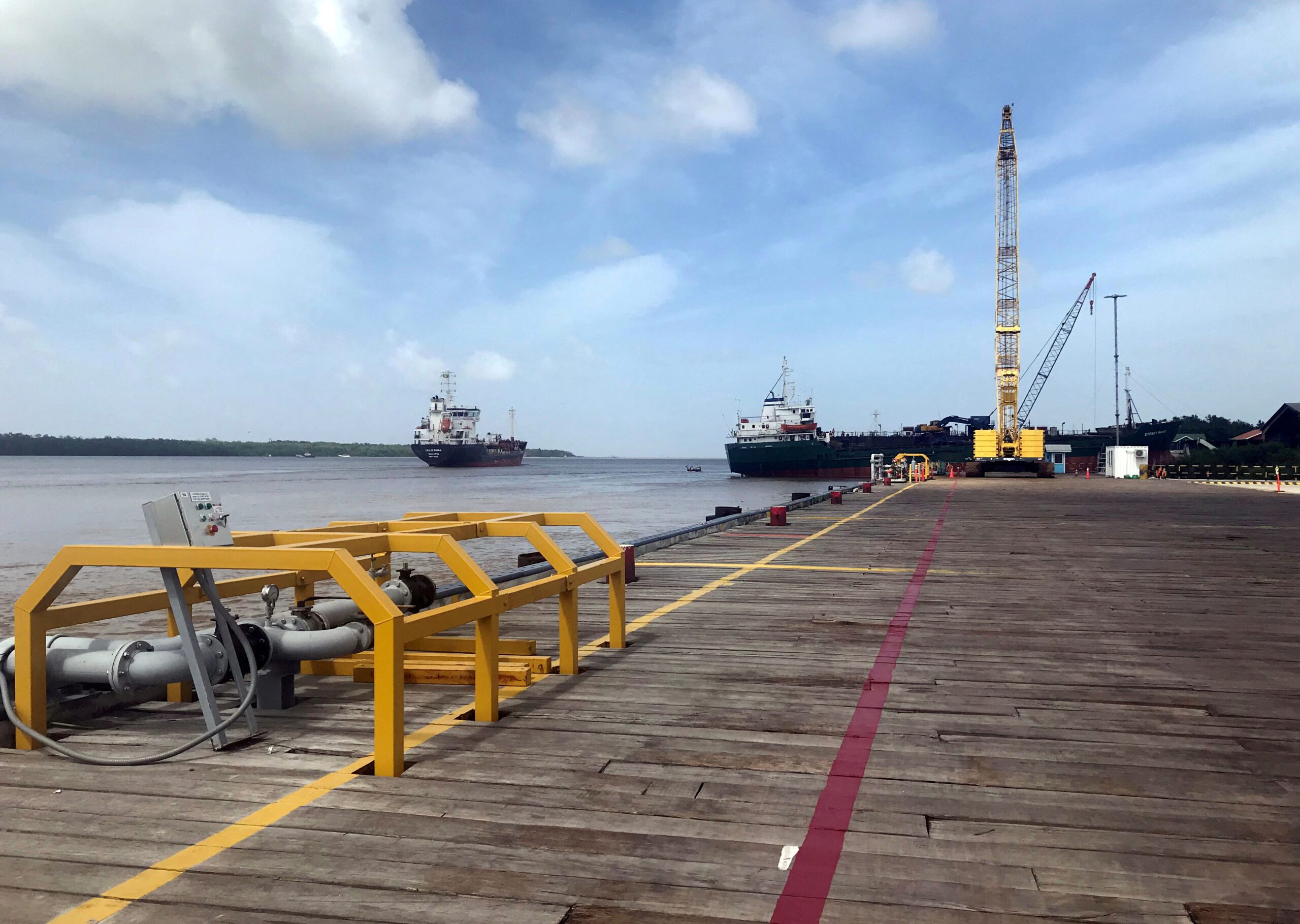 FILE PHOTO: Vessels carrying supplies for an offshore oil platform operated by Exxon Mobil are seen at the Guyana Shore Base Inc wharf on the Demerara River, south of Georgetown, Guyana January 23, 2020. REUTERS/Luc Cohen/File Photo/File Photo