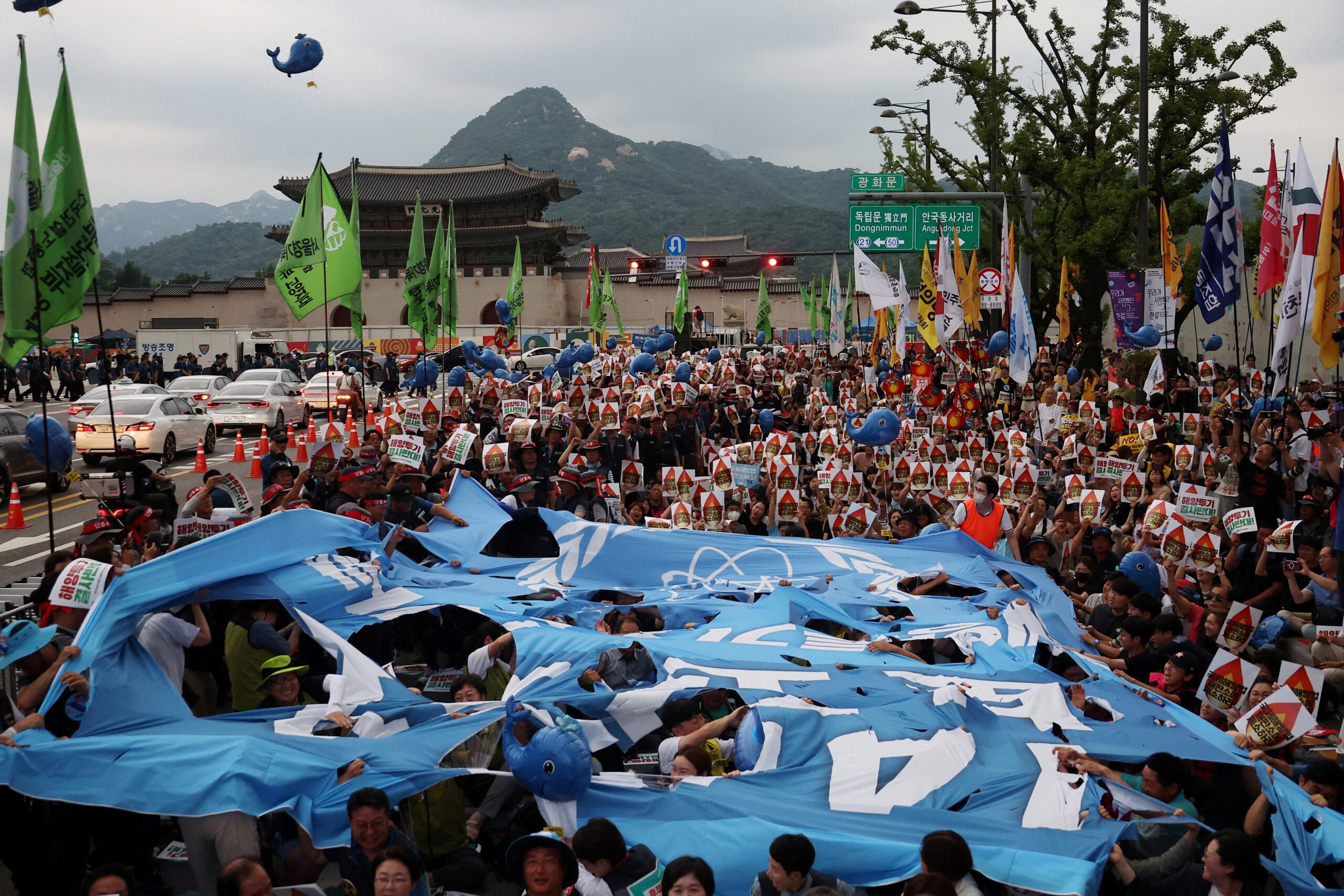 South Korean people tear up a giant banner depicting the logo of the International Atomic Energy Agency (IAEA) during a protest against Japan's plan to discharge treated radioactive water from the tsunami-wrecked Fukushima plant into the ocean, in central Seoul, South Korea, July 8, 2023. REUTERS/Kim Hong-Ji/File Photo