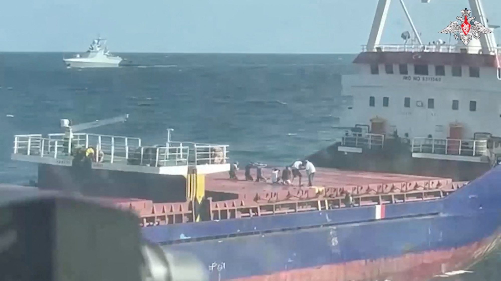 A still image from a video, released by Russia's Defence Ministry, shows what it said to be crew members kneeling down on the deck during an operation held by Russian navy officers to board the Palau-flagged Sukru Okan vessel