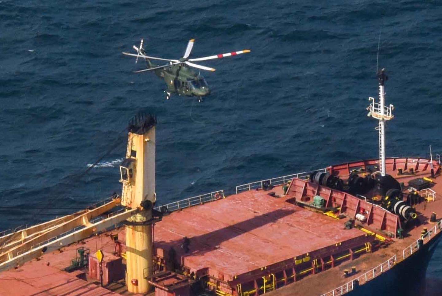 An Irish Defence Force helicopter flies above the deck of the Matthew bulk carrier