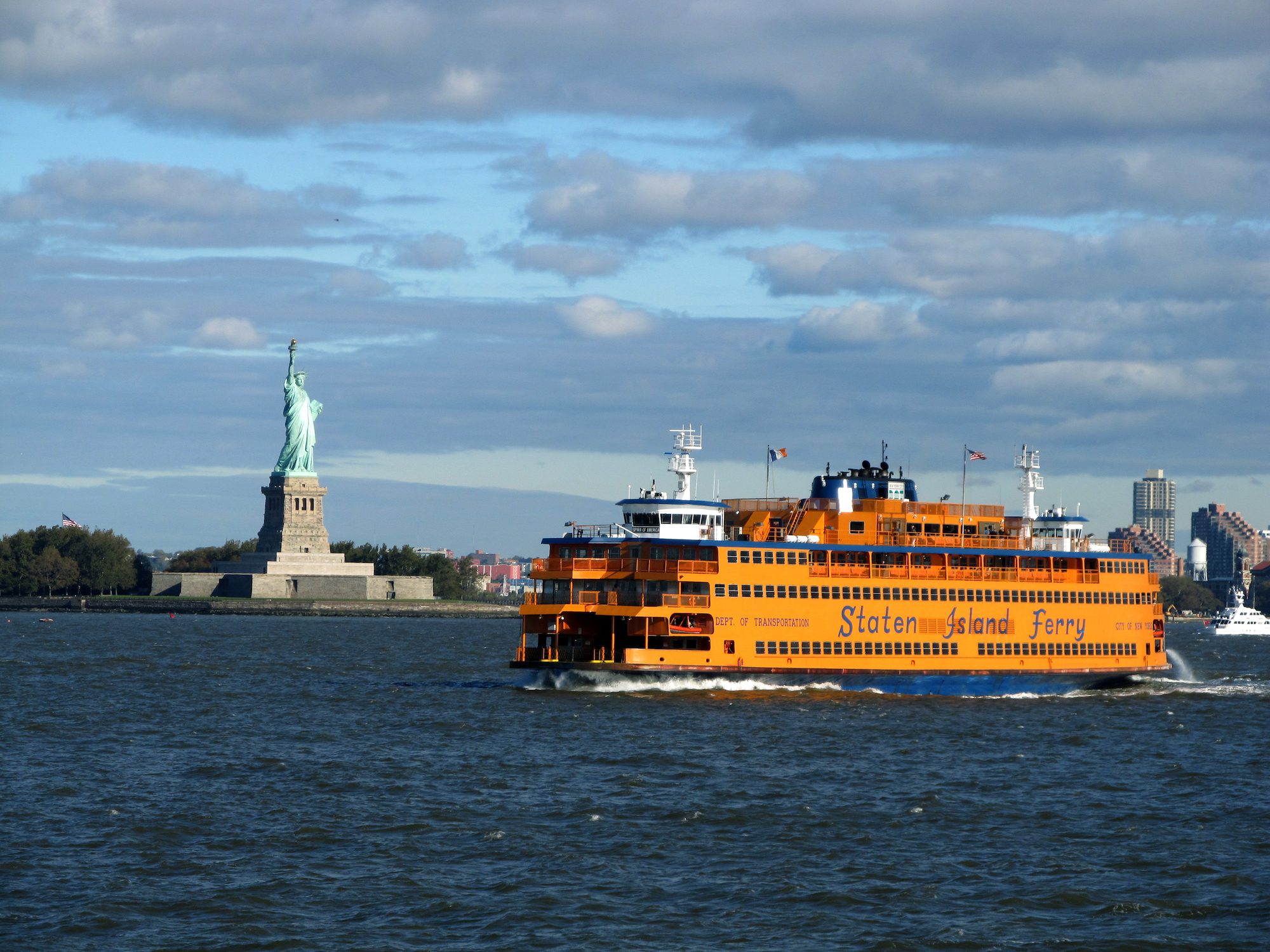 A Staten Island Ferry passes the Statue of Liberty in New York Harbor