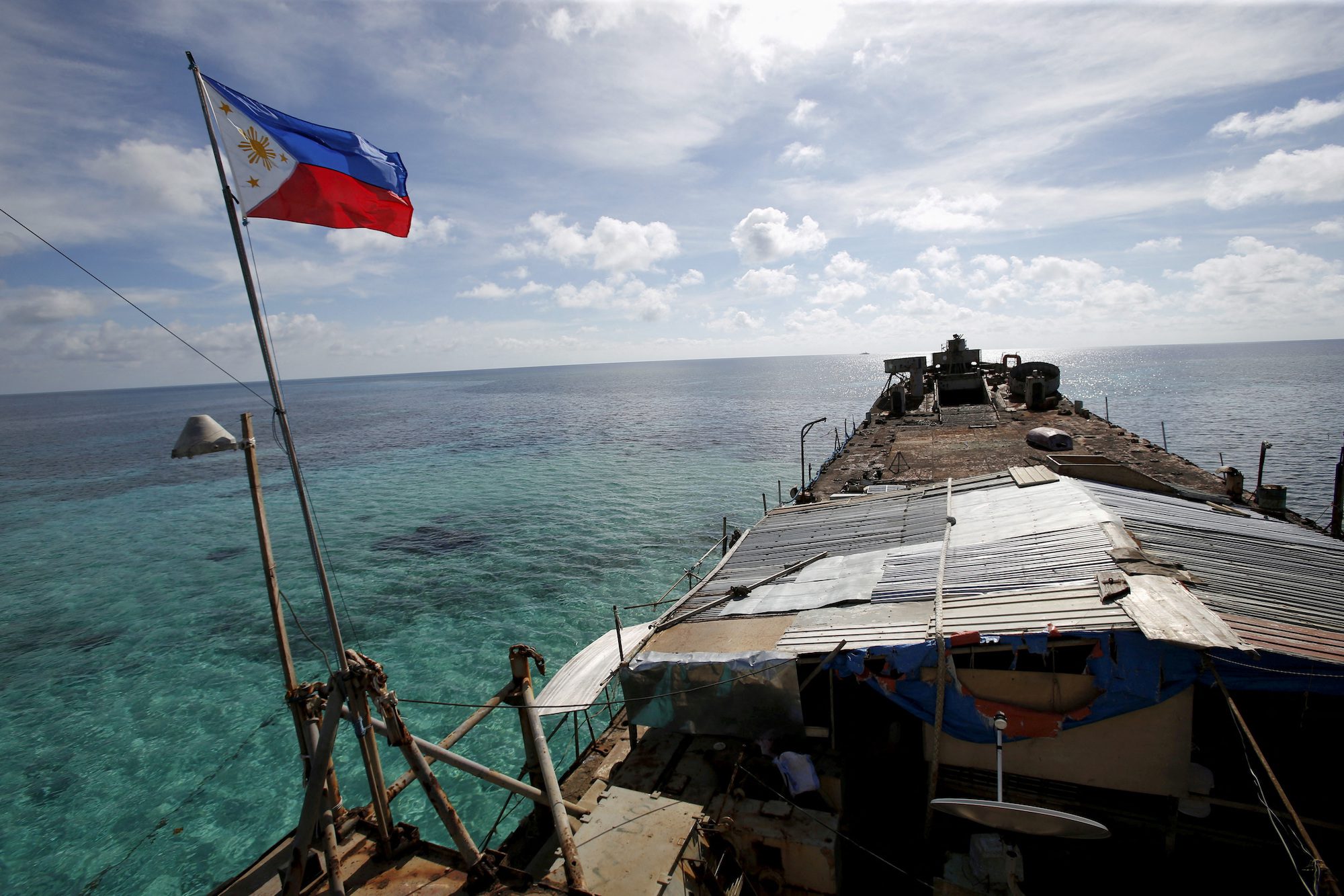 FILE PHOTO: A Philippine flag flutters from BRP Sierra Madre, a dilapidated Philippine Navy ship that has been aground since 1999 and became a Philippine military detachment on the disputed Second Thomas Shoal, part of the Spratly Islands, in the South China Sea March 29, 2014. REUTERS/Erik De Castro/File Photo