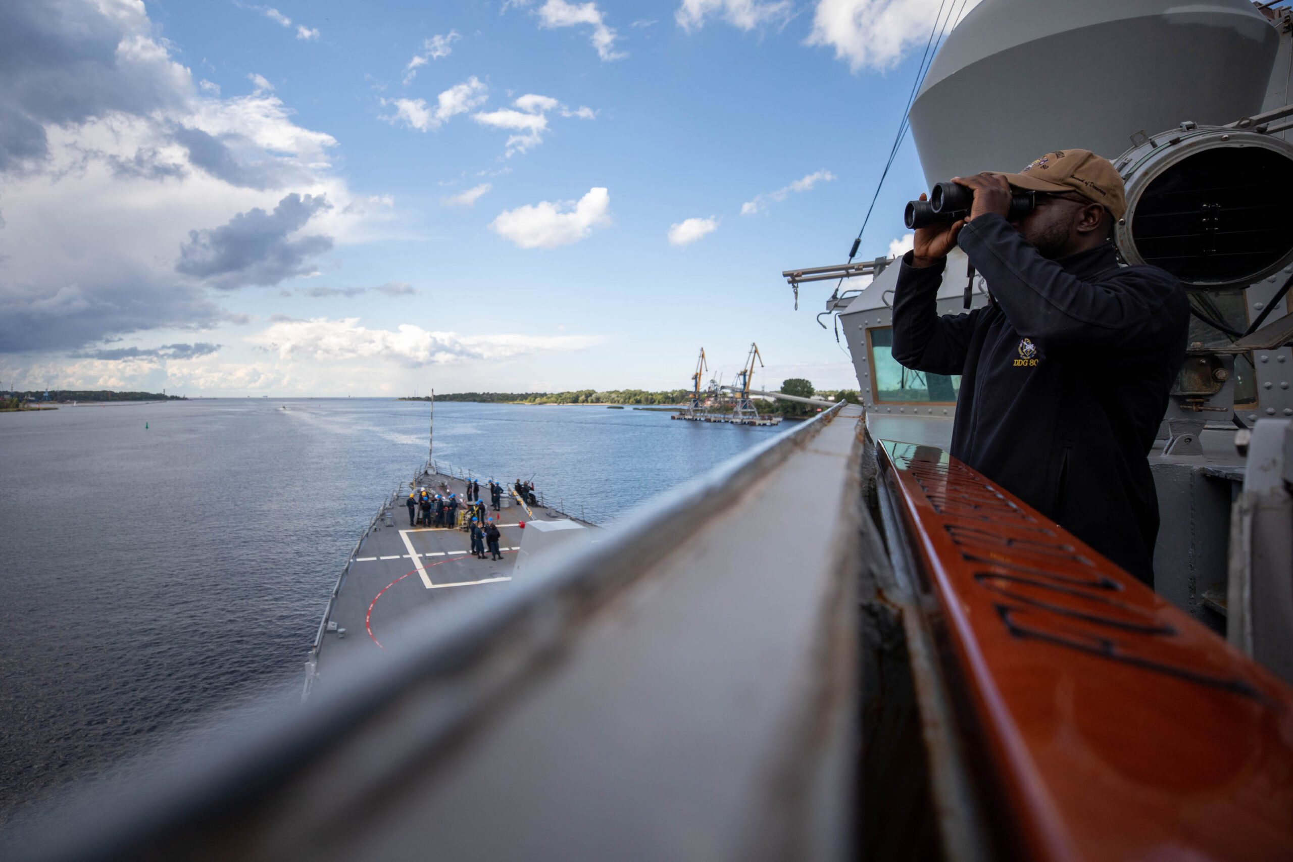 Navy officer looking through binoculars out to into the Baltic