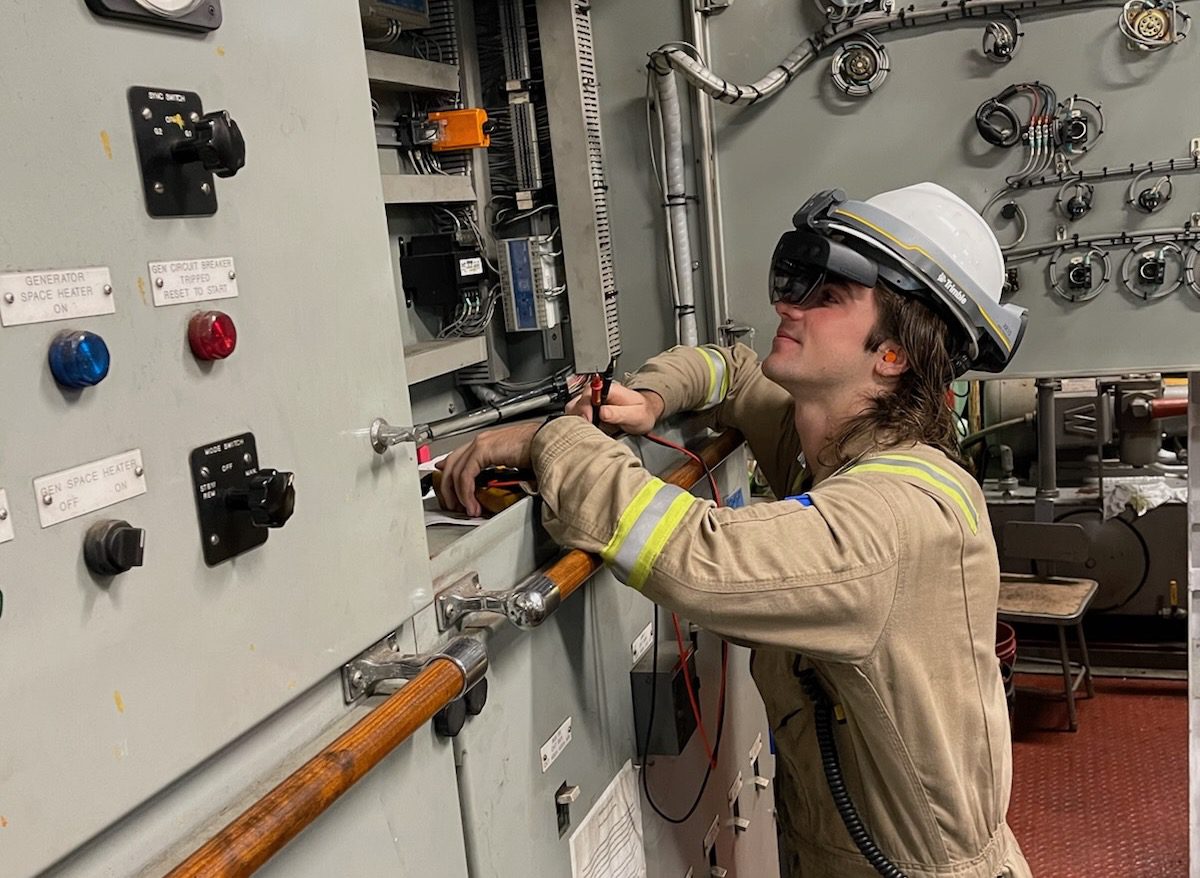 An engineer uses AR goggles on a ship