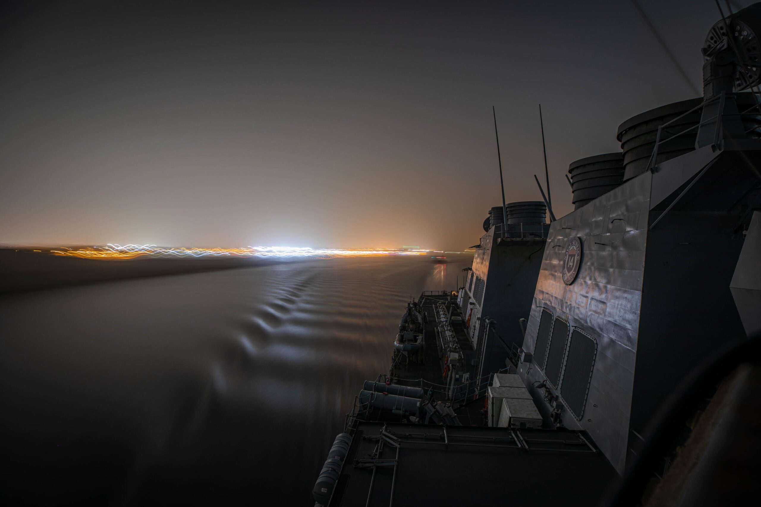 USS Carney underway at night in the suez canal