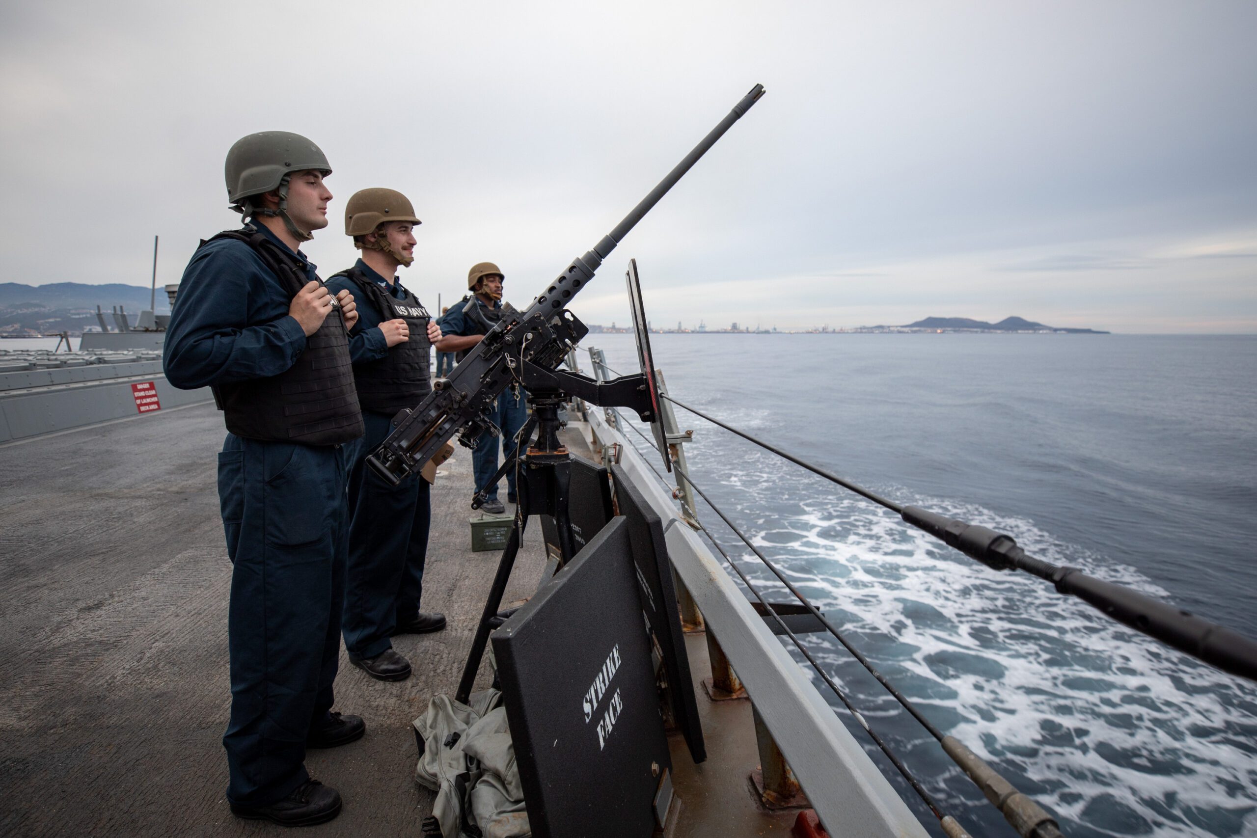Navy Sailors man their guns on the deck of the USS Laboon