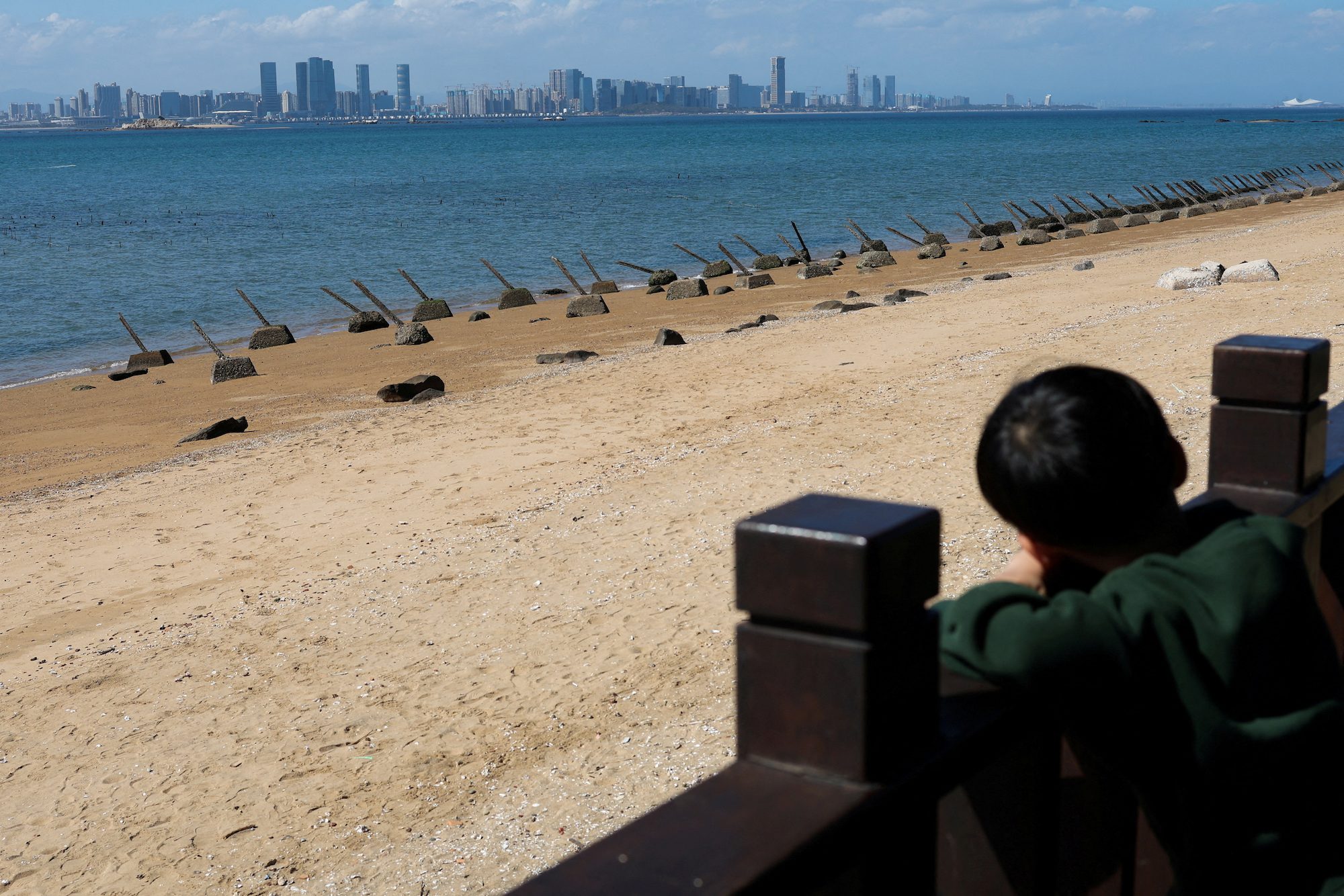 A child looks on towards China's Xiamen city from the coast in Kinmen, Taiwan February 21, 2024. REUTERS/Ann Wang