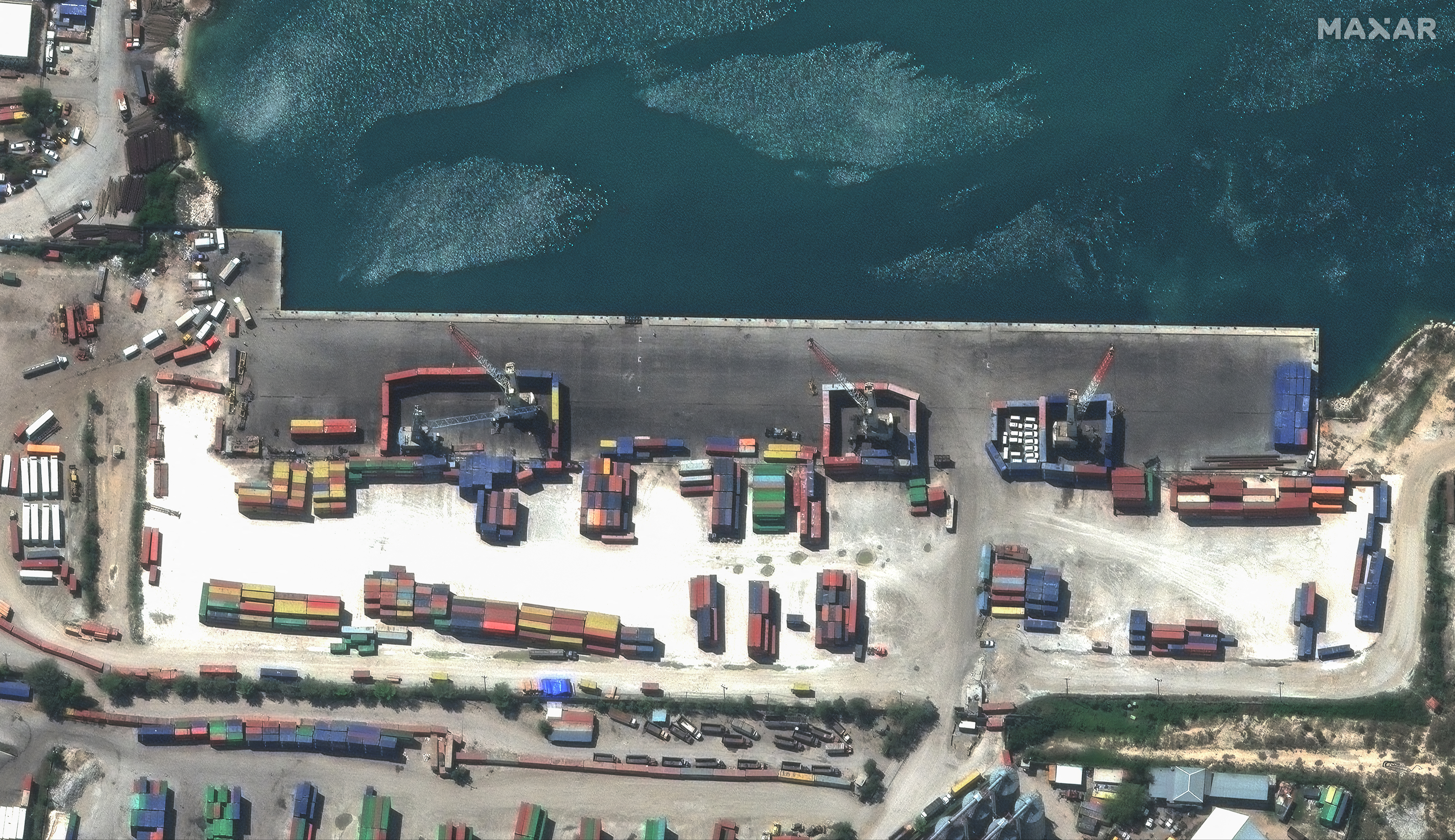 A satellite image shows shipping containers used to block access to heavy cranes, in Port-au-Princ. In this handout image. Maxar Technologies/Handout via REUTERS