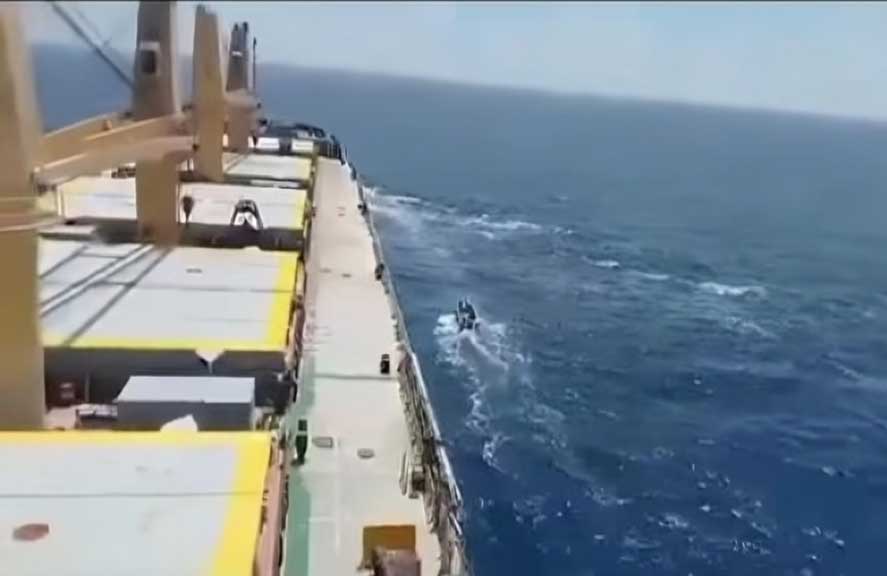A boat sails next to a shipping vessel MV Abdullah in this screengrab obtained from a social media video released on March 12, 2024