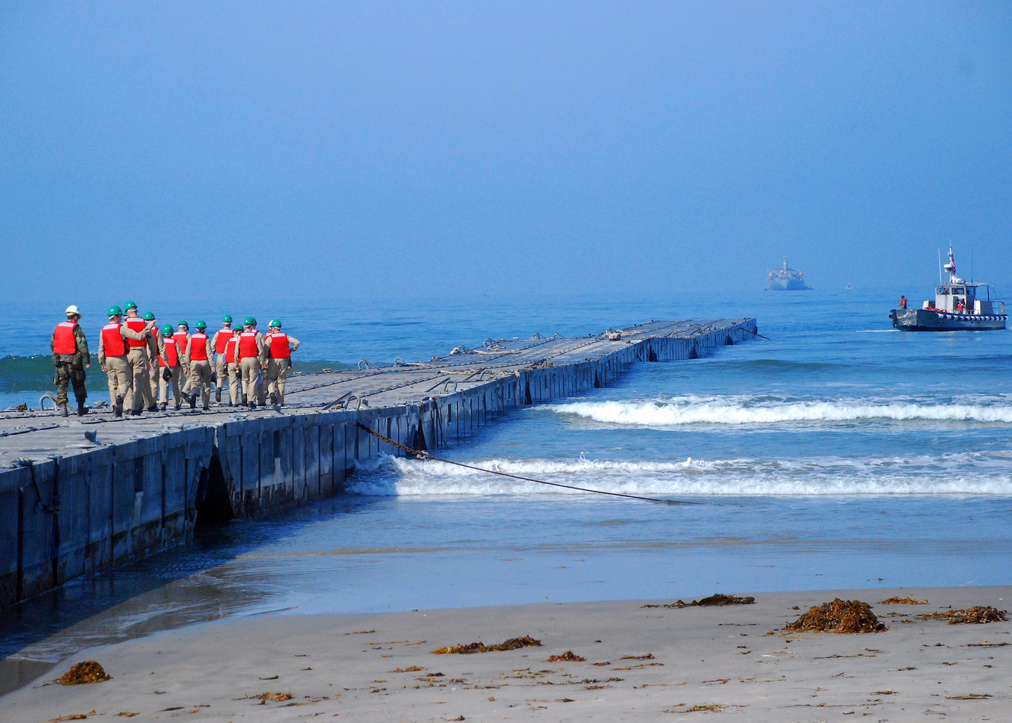 FILE PHOTO: Midshipmen walk along the Joint Logistics Over-The-Shore (JLOTS) Admin Pier, an 800-foot long, small-craft pier, created by attaching non-powered Navy lighterage causeway sections together. U.S. Navy photo taken on July 15, 2008.