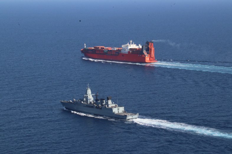 An EUNAVFOR warship escorts a merchant vessel in the Red Sea