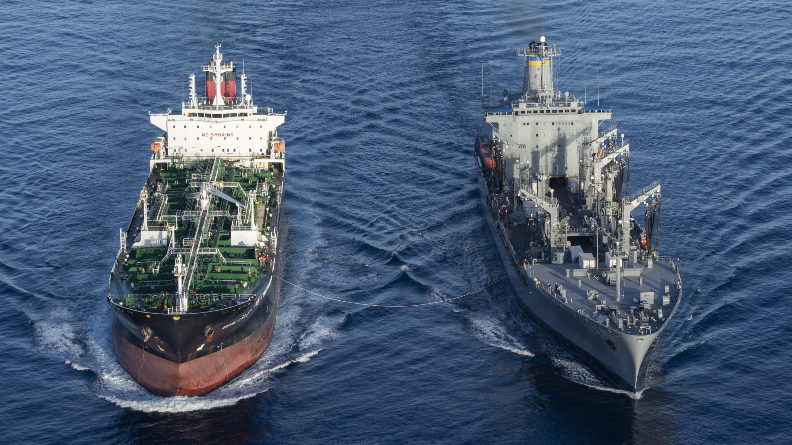 US Navy warship and US Merchant Marine tanker underway at sea