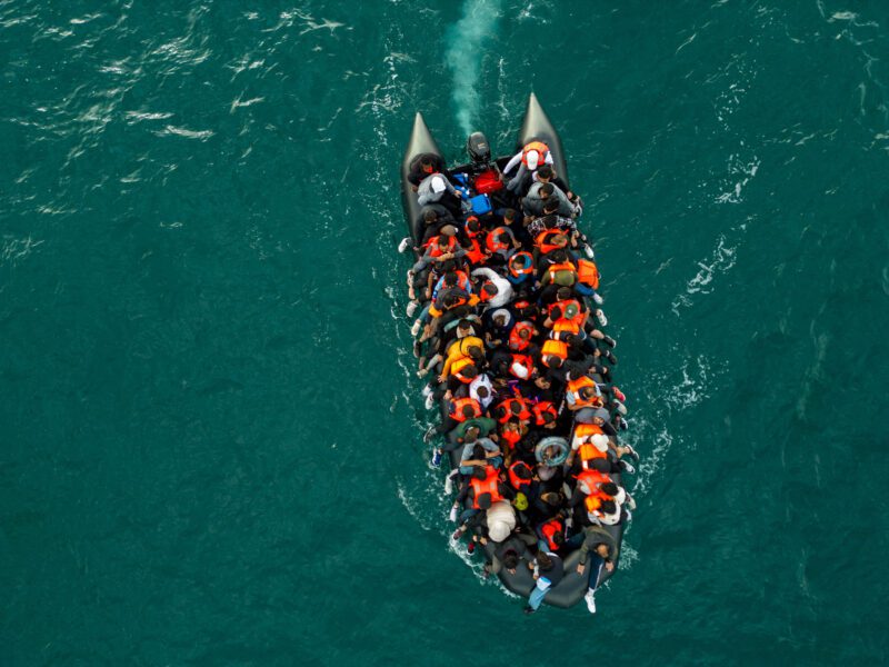 Migrants cross the english channel in boats wearing lifejackets