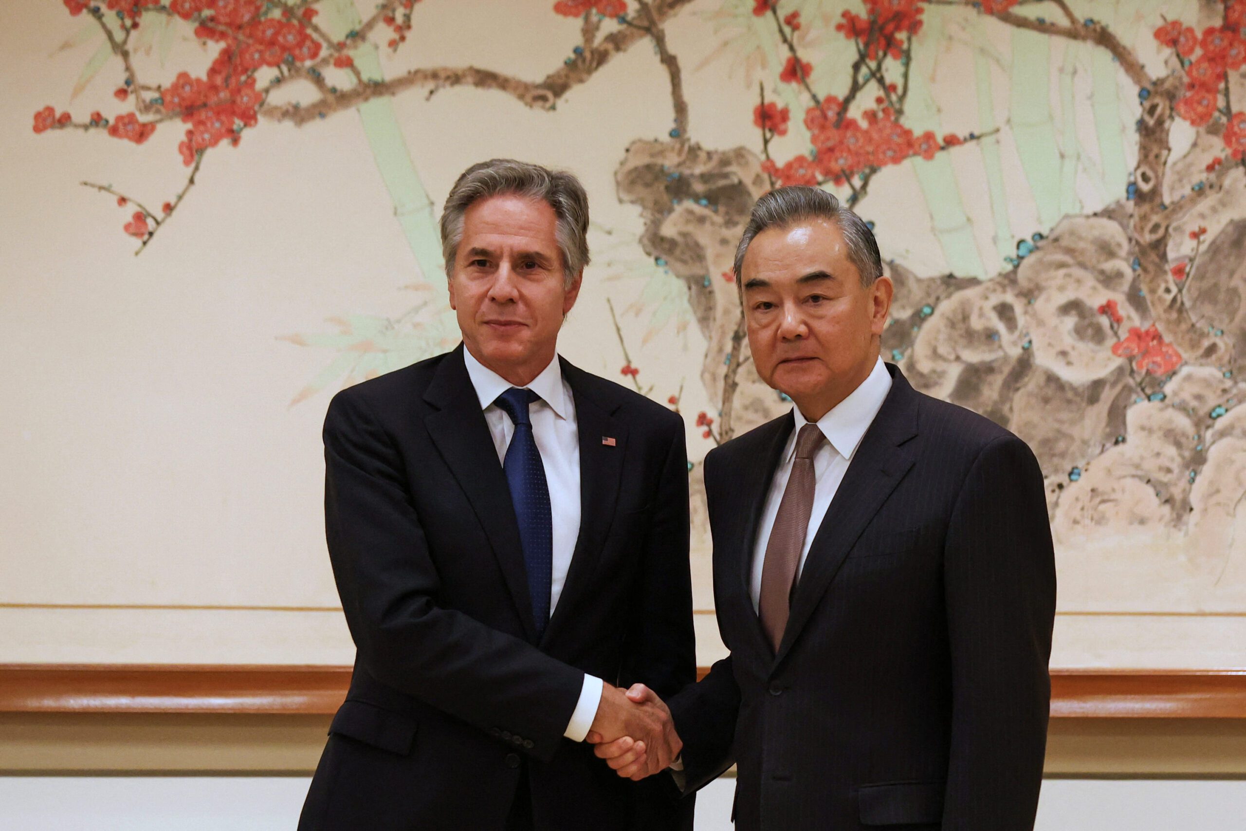 US Sec State Tony Blinken shacking hands with China Diplomat