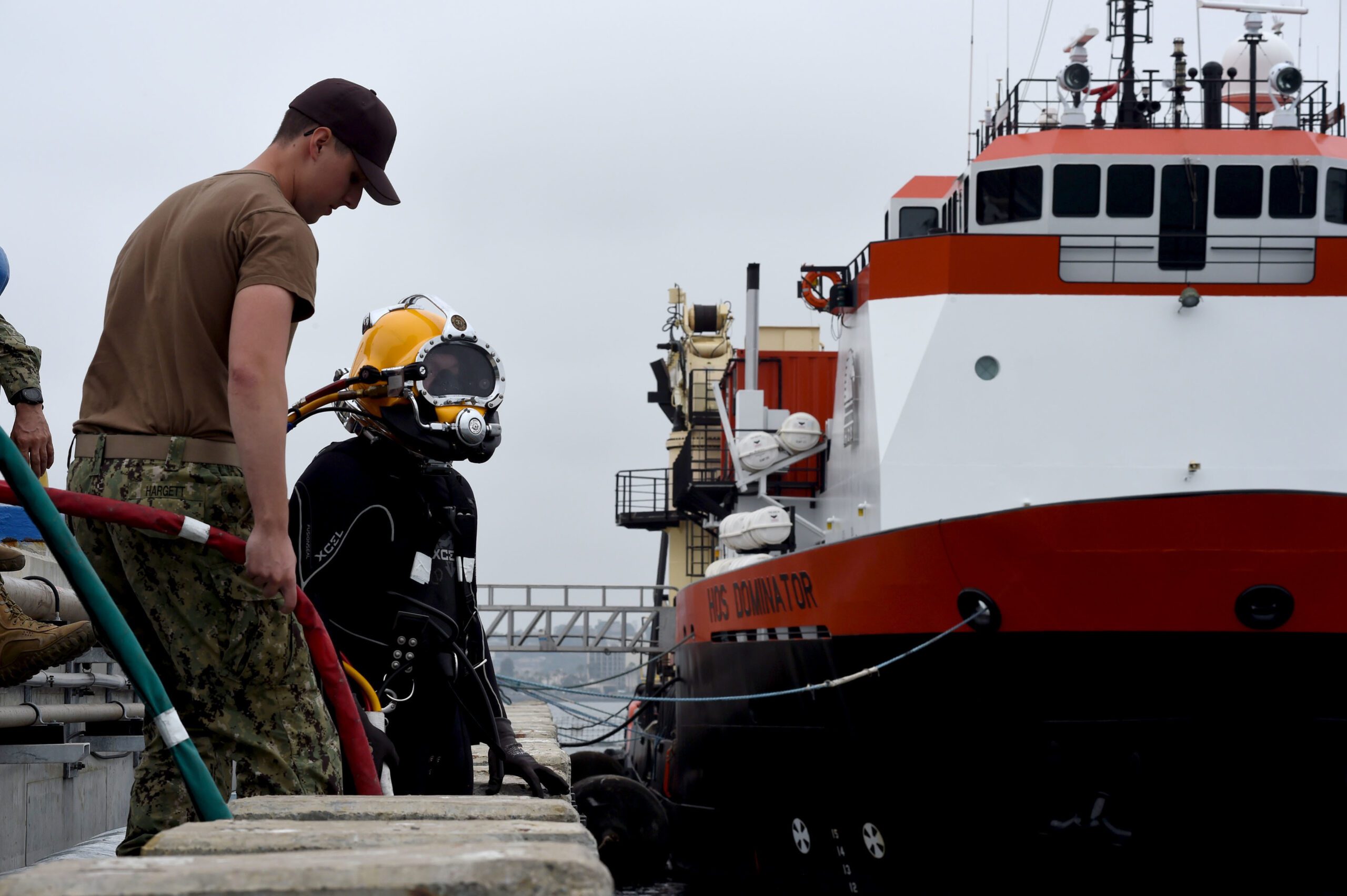 Navy Diver 1st Class Mark Hargett prepares Navy Diver 1st Class Casey Smith for a dive training exercise.