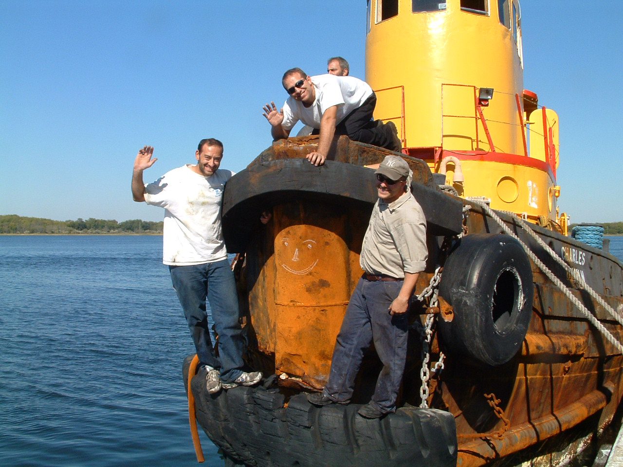 Crew refurbishing an old tug-boat in New York Harbor