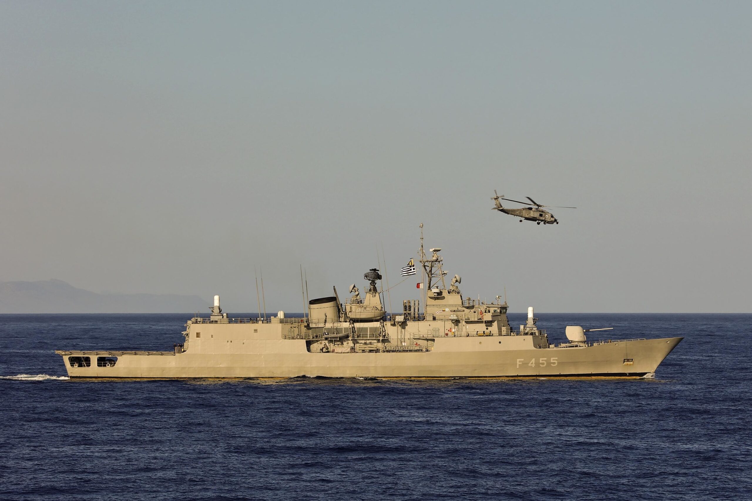 Greek navy warship underway with a helicopter during a NATO naval exercise