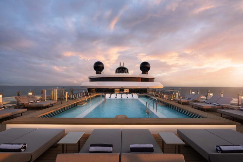 Pool deck aboard a superyacht at sea with clouds int he background