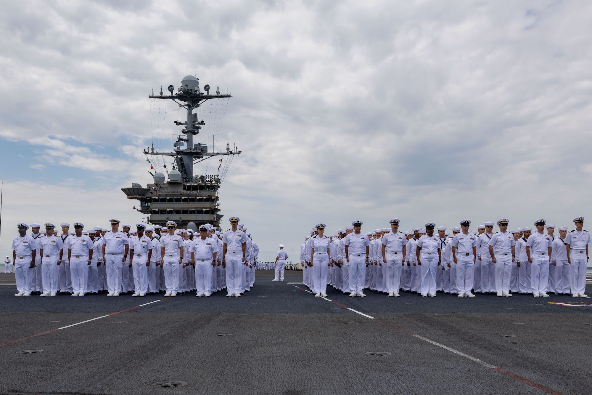 Sailors muster with their departments on the flight deck of the Nimitz-class aircraft carrier USS Harry S. Truman (CVN 75)