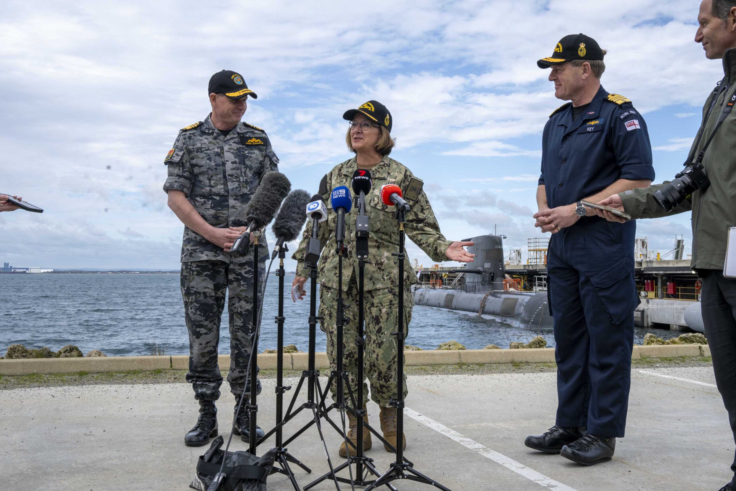 US Navy Chief of Naval Operations at a microphone talking with allies