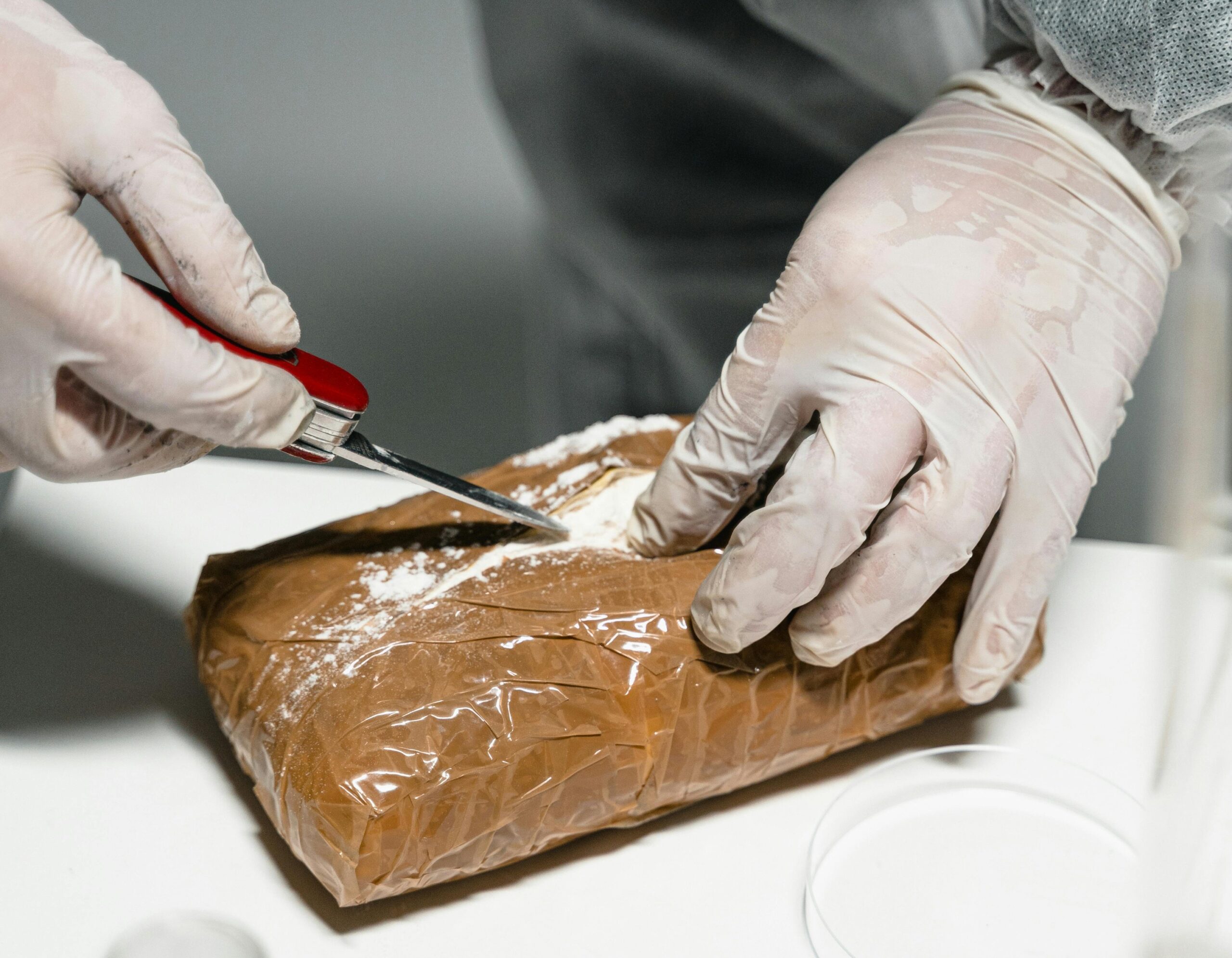 Image of a lab assistant handling a brick of cocaine