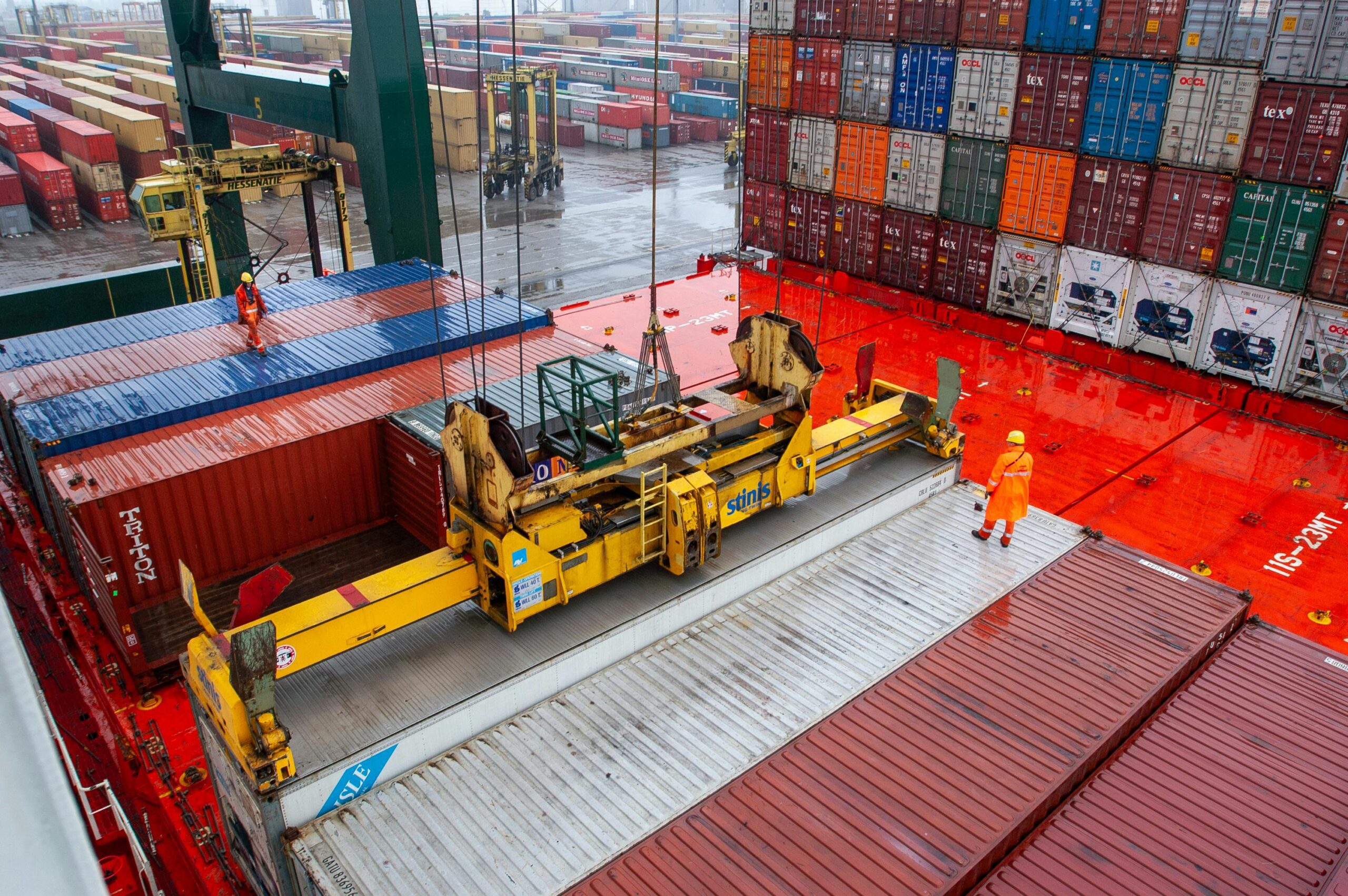 Longshore workings lifting a shipping container with a port crane