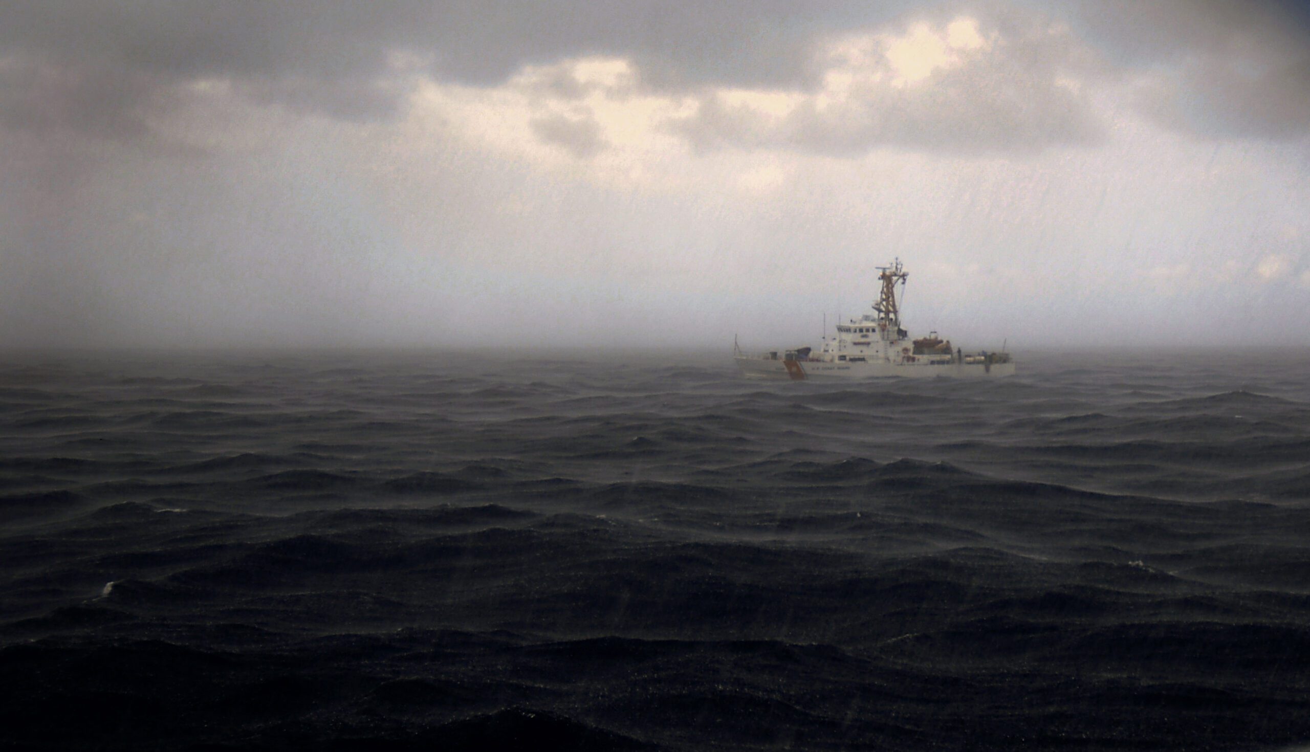 USCG Cutter at sea under a dark sky