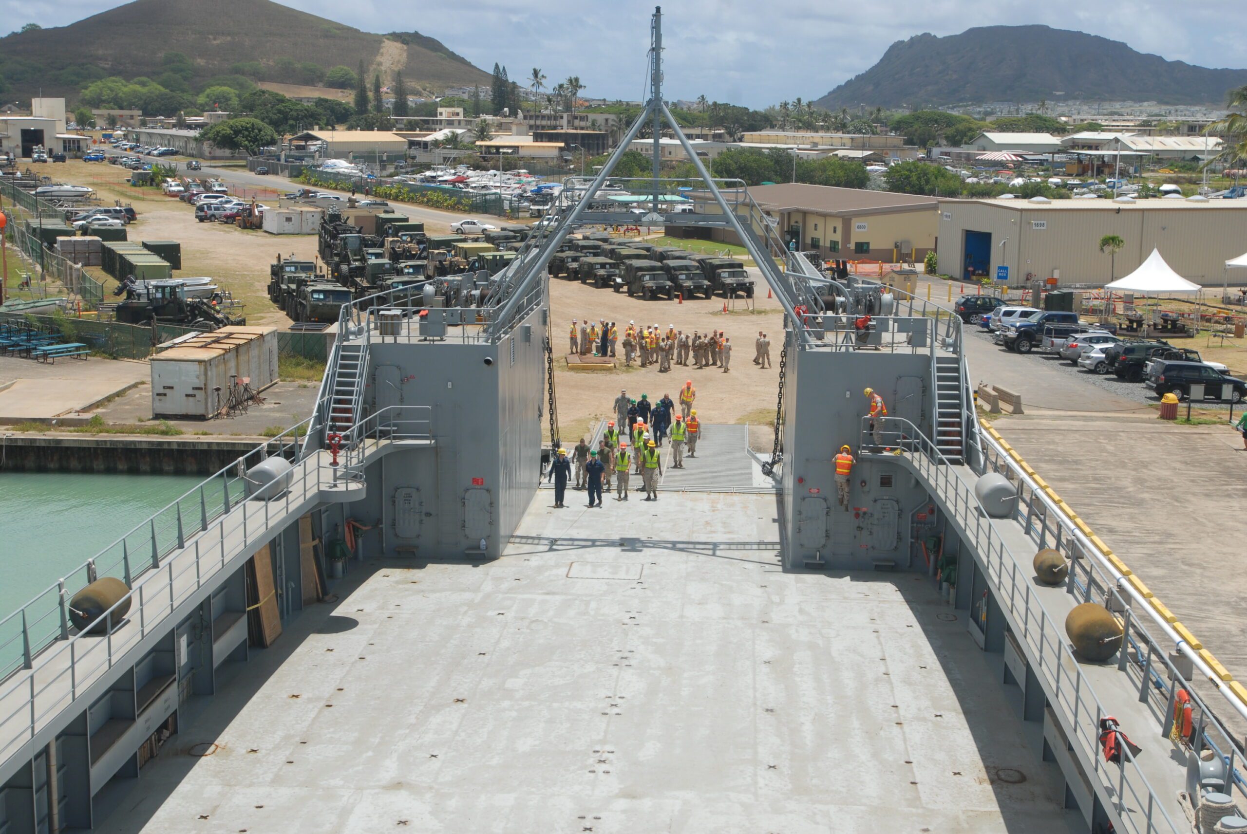 Empty Army watercraft backed up onto a beach with tanks and equipment waiting to load