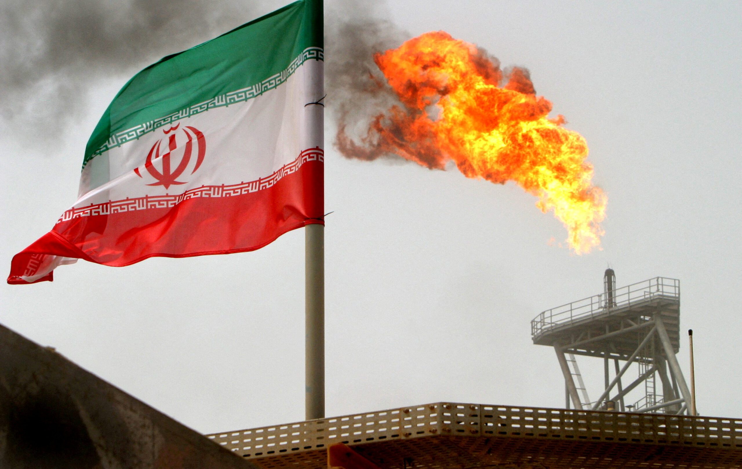 A gas flare on an oil production platform is seen alongside an Iranian flag in the Gulf.REUTERS/Raheb Homavandi//File Photo