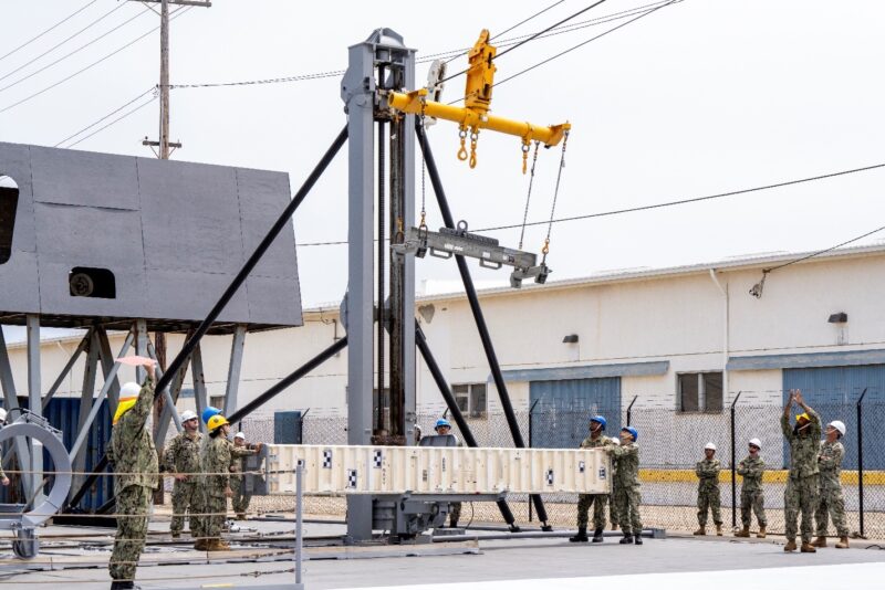 A navy missile being swung on a wire and pully system  during testing on land