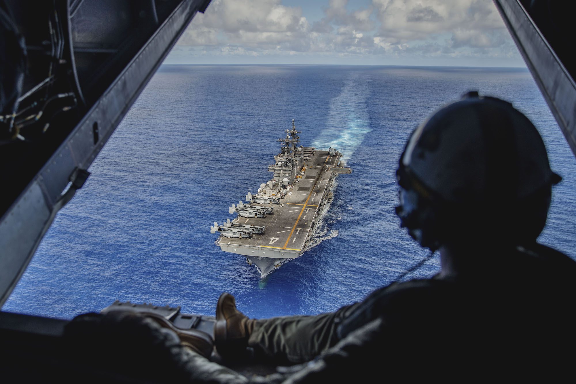 U.S. Marine Corps Sgt. Mitchell Parcell, a V-22 tiltrotor crew chief assigned to Marine Medium Tiltrotor Squadron (VMM) 165 (Reinforced), 15th Marine Expeditionary Unit, and a native of Montana, observes the amphibious assault ship USS Boxer (LHD 4) in the Luzon Strait Oct. 8, 2024.