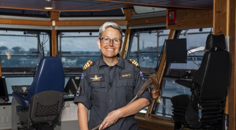 Captain on the bridge of the ship HMNZS Manawanui weaing coveralls