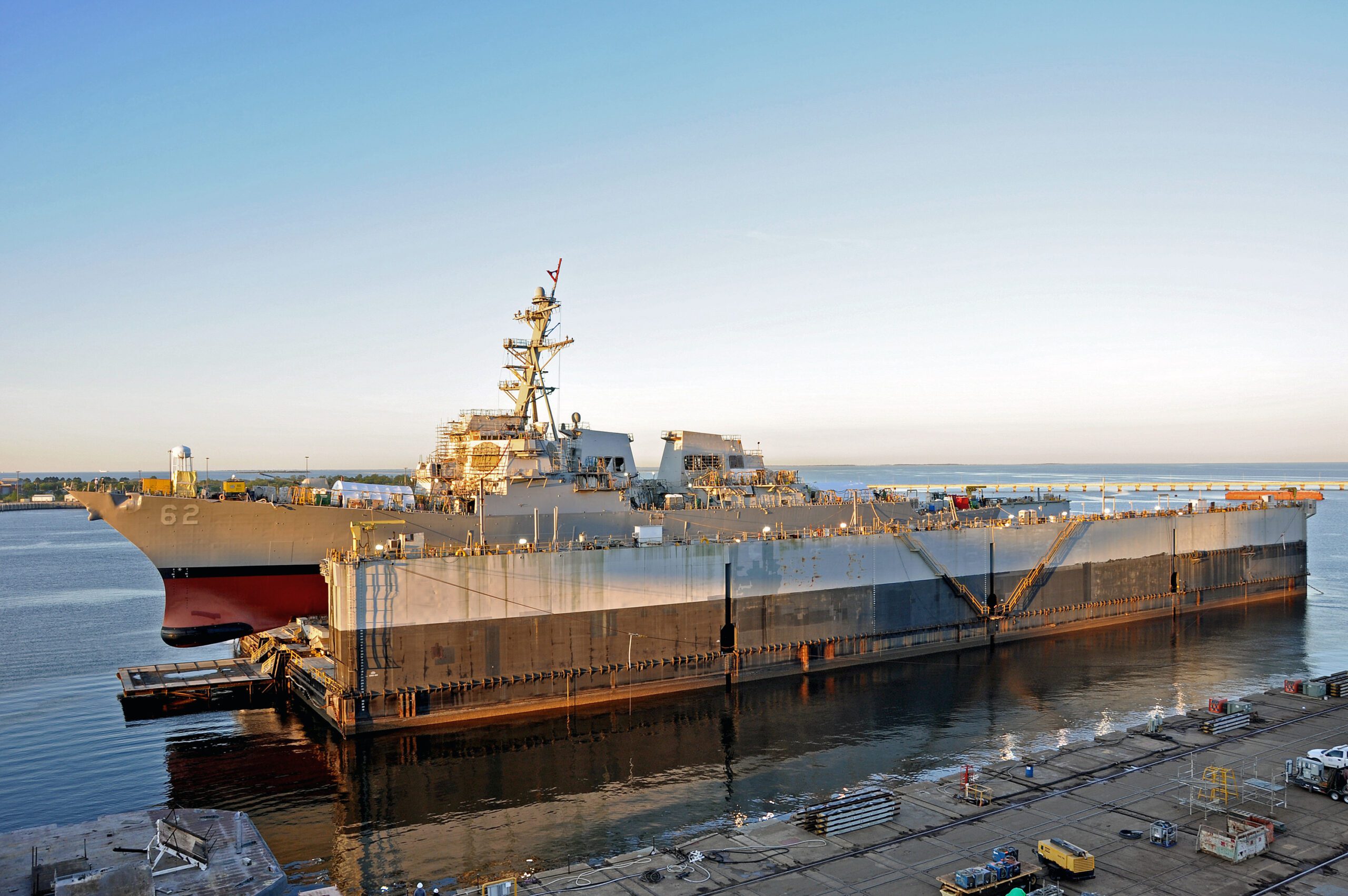 US Navy warship in a shipyard's floating drydock for repair