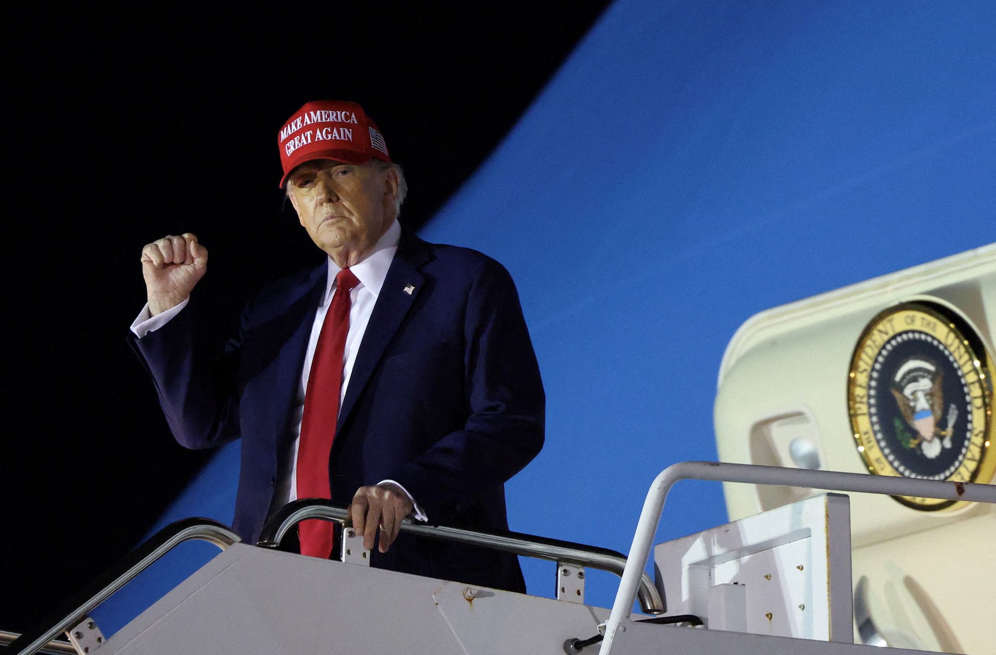 President Donald Trump pumps his fist as he steps from Air Force One upon his arrival in West Palm Beach, Florida, U.S., February 28, 2025.