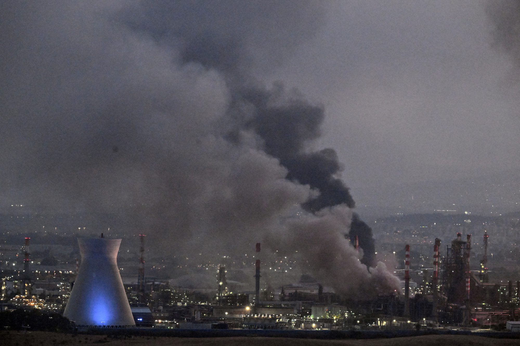 Smoke rises at an impacted facility site following missile attack from Iran on Israel, at Haifa