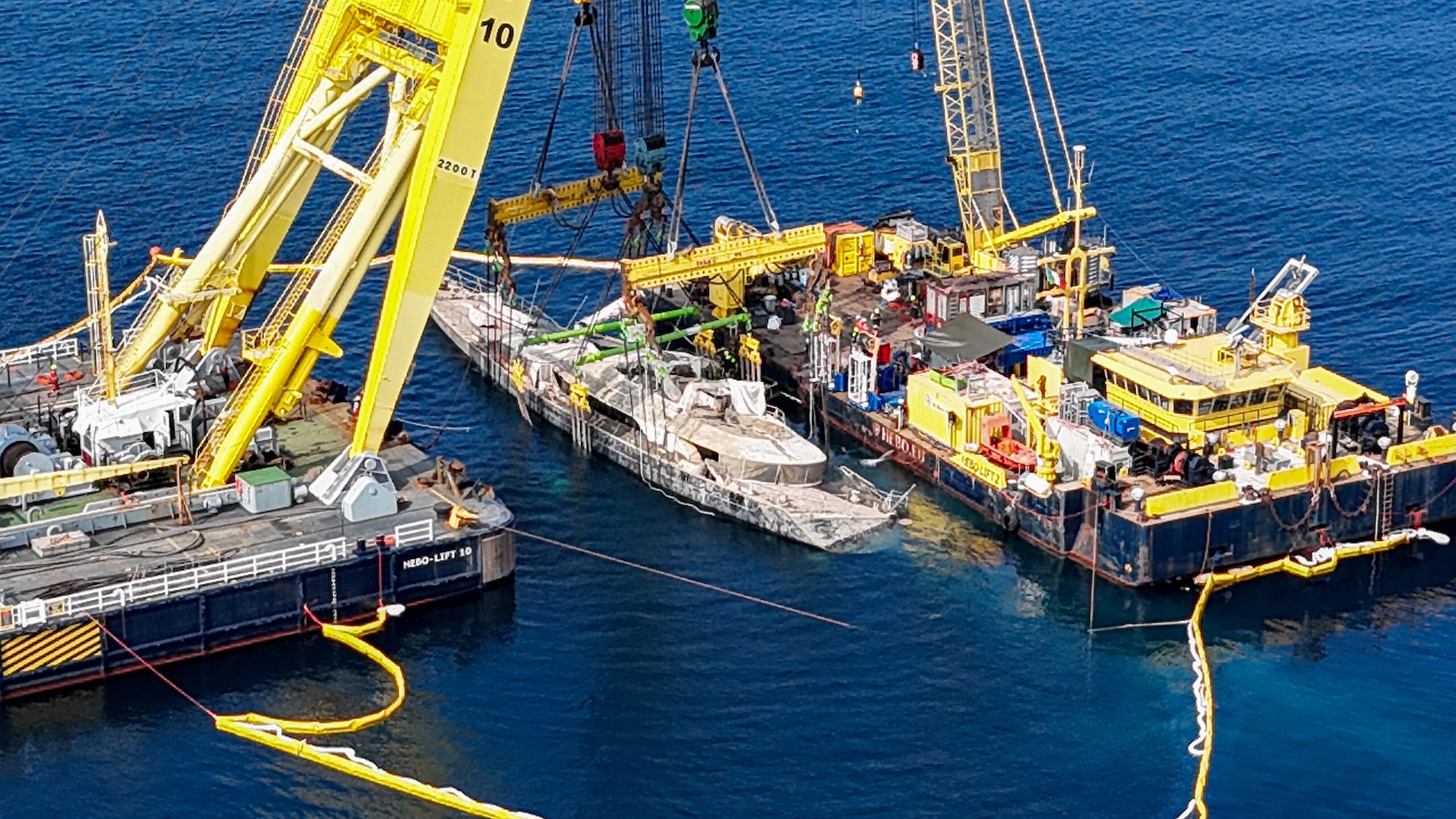 A drone view shows floating crane ships HEBO LIFT 10 and HEBO LIFT 2 recovering the "Bayesian" yacht of British tech entrepreneur Mike Lynch