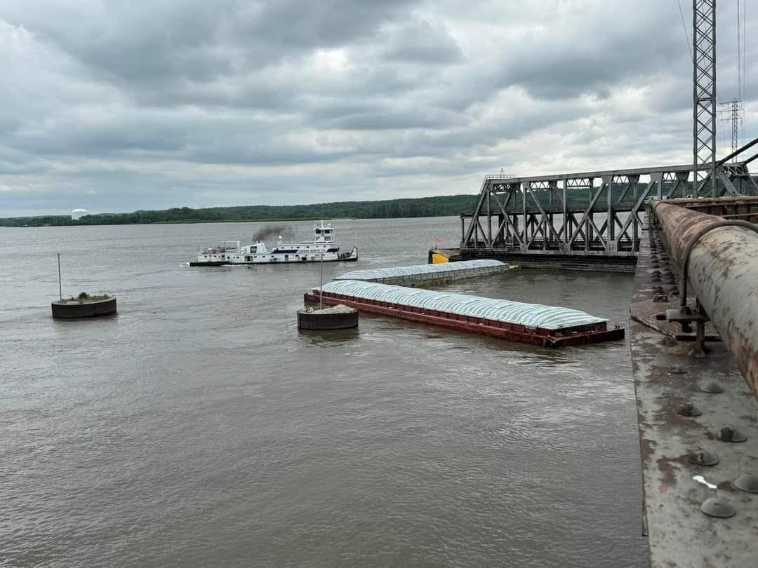 Barges IN122011 and IN155499 immediately after impact blocking the primary channel. The Joe B. Wyatt is shown in the background