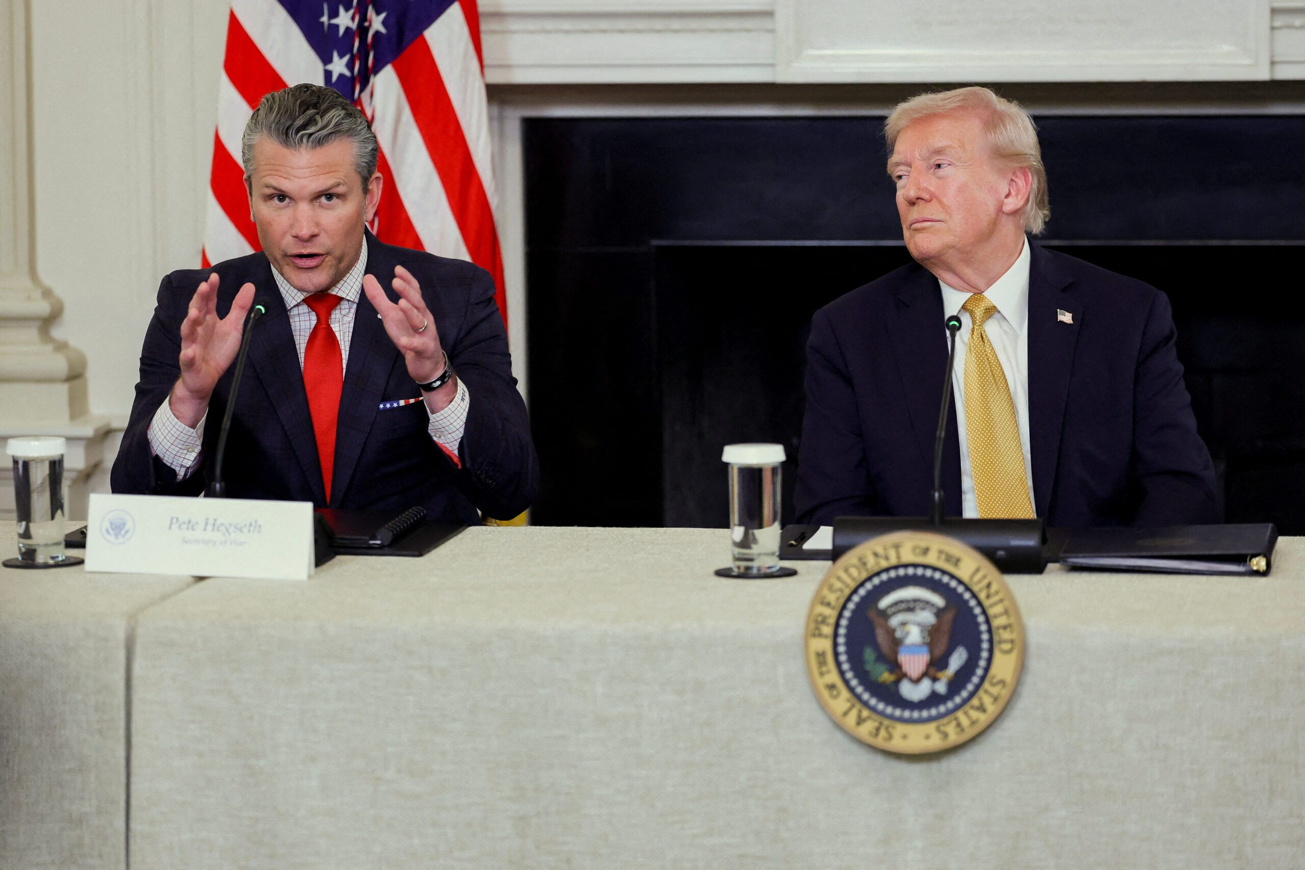 U.S. Secretary of Defense Pete Hegseth speaks next to U.S. President Donald Trump during Trump's announcement regarding his administration's policies against cartels and human trafficking, from the State Dining Room at the White House in Washington