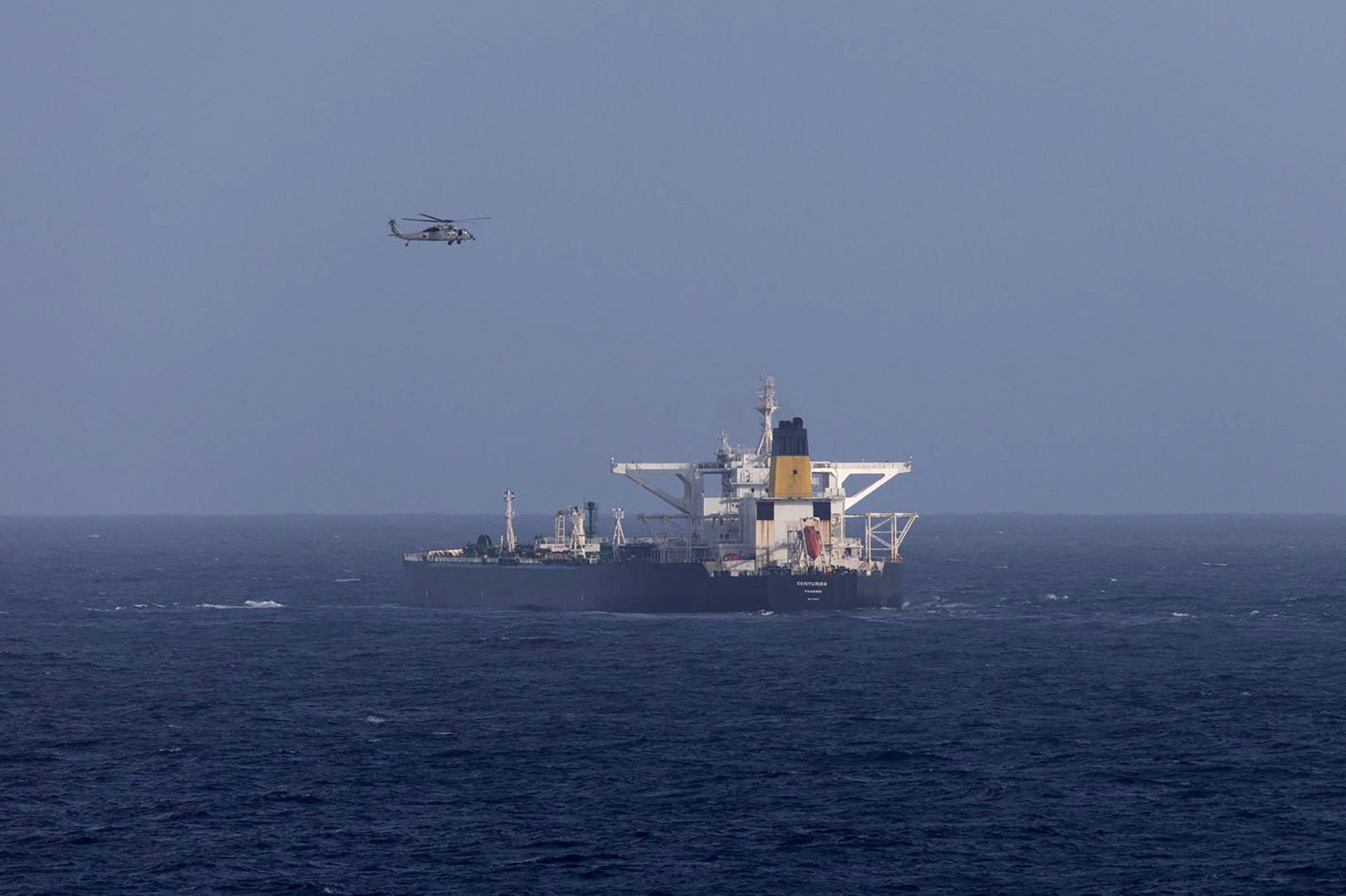 A U.S. military helicopter flies over the Panama-flagged Centuries, which was intercepted by the U.S. Coast Guard, days after U.S. President Donald Trump announced a "blockade" of all sanctioned oil tankers entering and leaving Venezuela, east of Barbados in the Caribbean Sea
