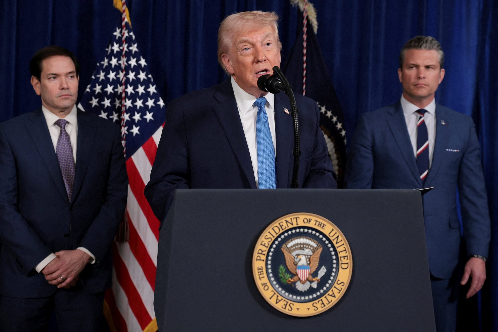 FILE PHOTO: U.S. President Donald Trump speaks as Secretary of State Marco Rubio and Secretary of Defense Pete Hegseth look on during a press conference following a U.S. strike on Venezuela where President Nicolas Maduro and his wife, Cilia Flores, were captured, from Trump's Mar-a-Lago club
