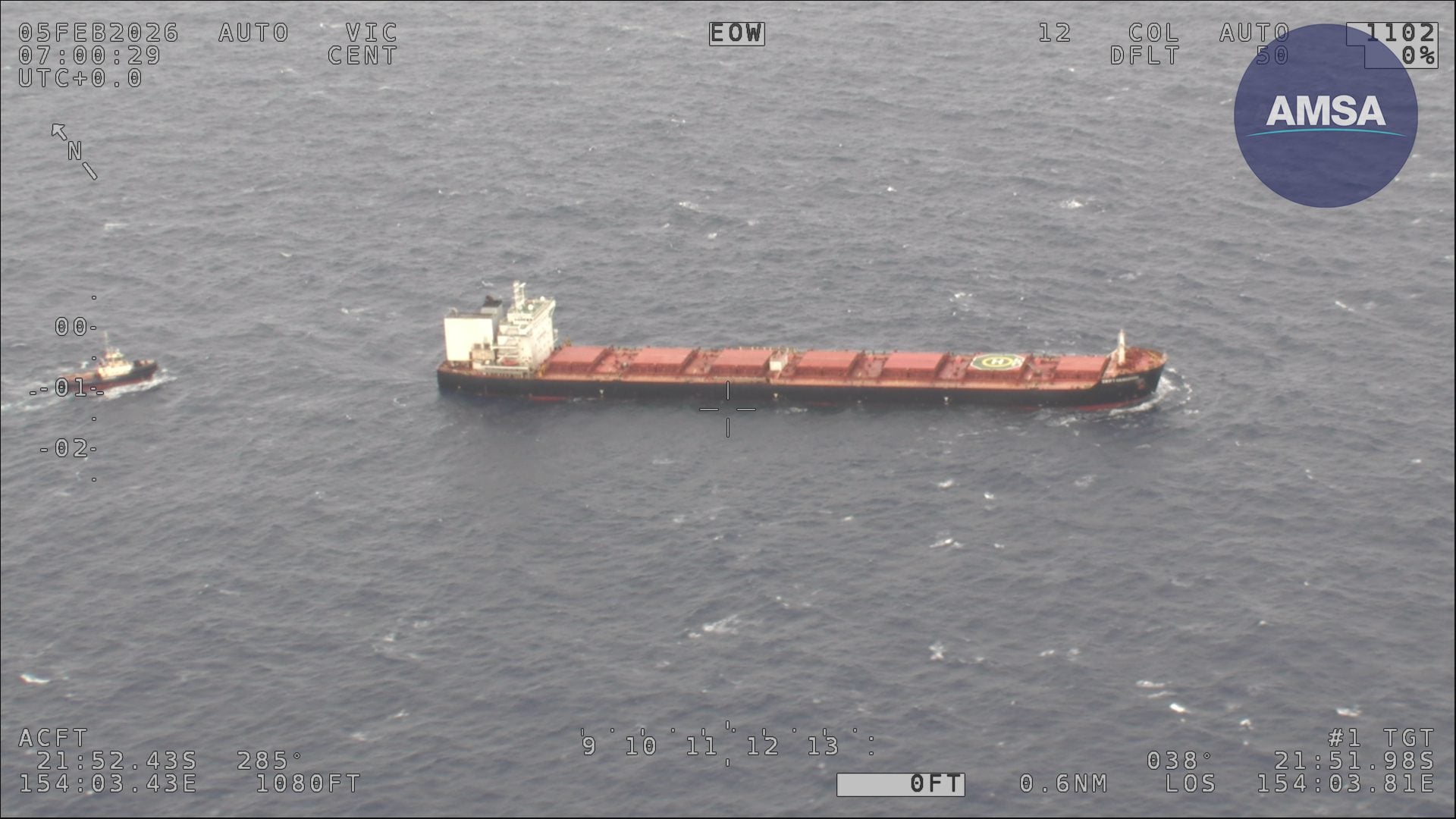Aerial view of bulk carrier Swift Hangzhou at sea with a tug alongside during emergency response near the Great Barrier Reef.