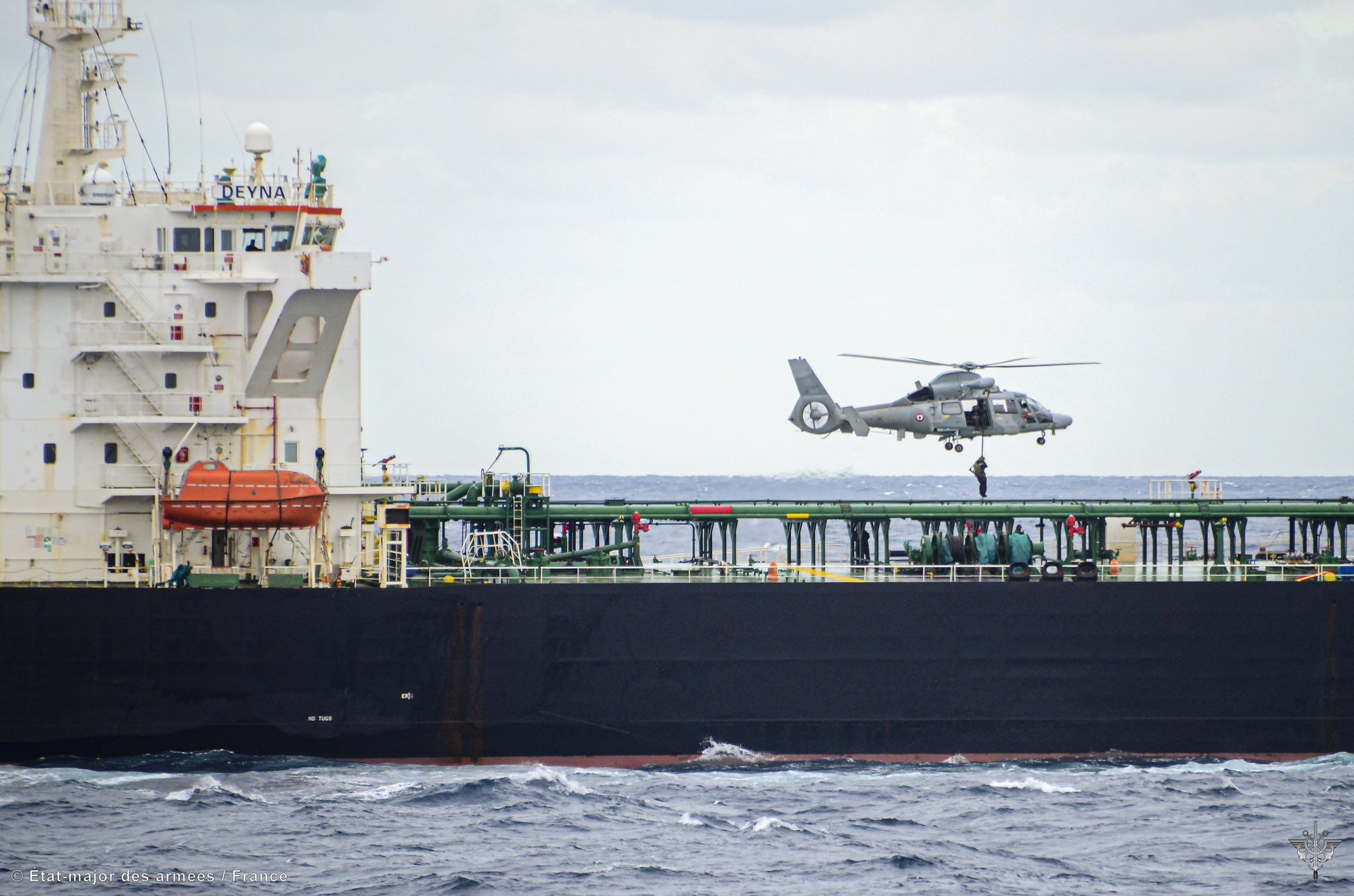 French Navy helicopter deploying boarding team onto oil tanker Deyna at sea during interception operation in the Mediterranean.