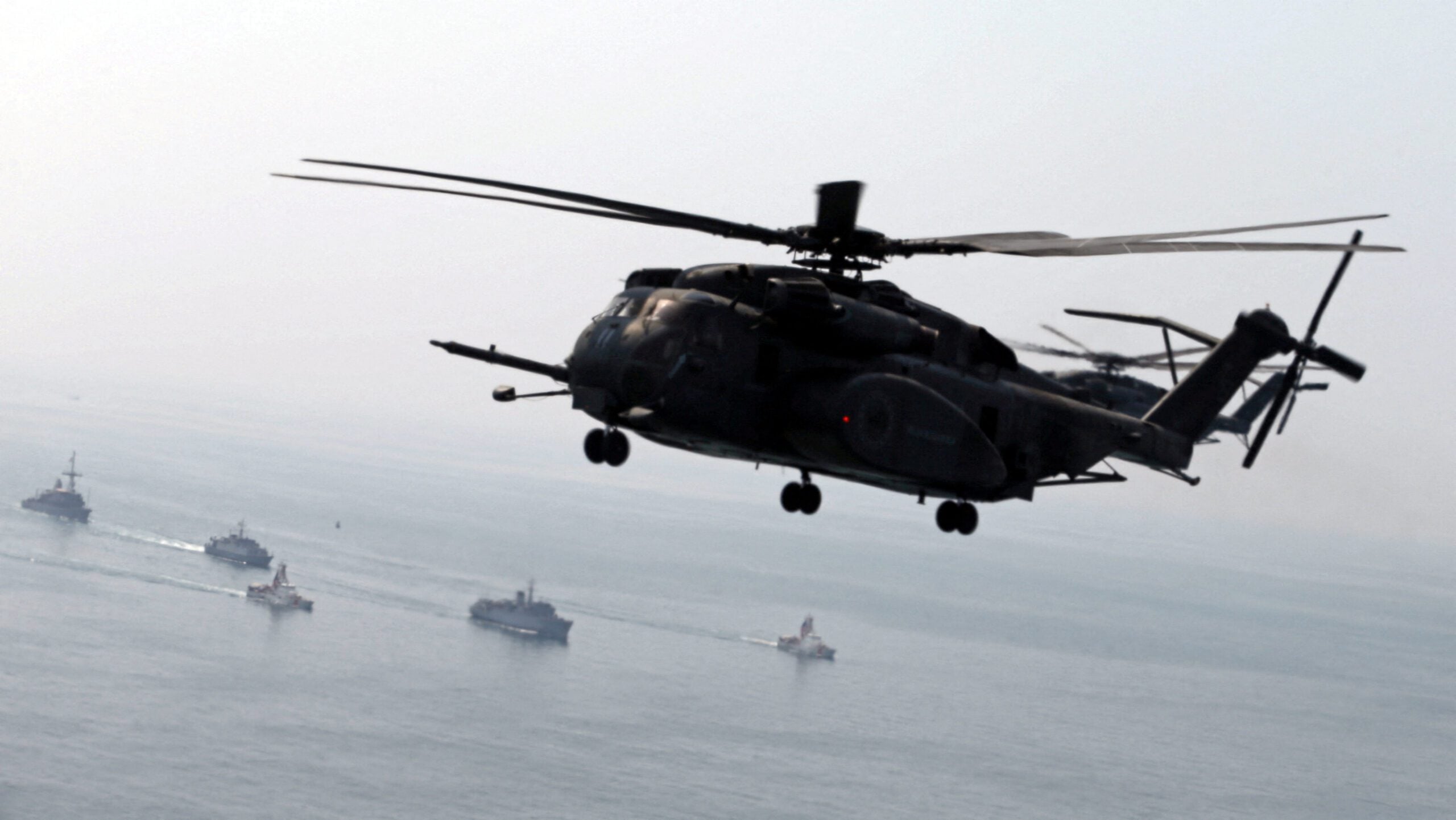A U.S. Navy MH-53E Sea Dragon helicopter flies over U.S. and U.K. Navy ships during a U.S. and U.K. Mine Countermeasures Exercise (MCMEX) taking place at the Arabian Sea