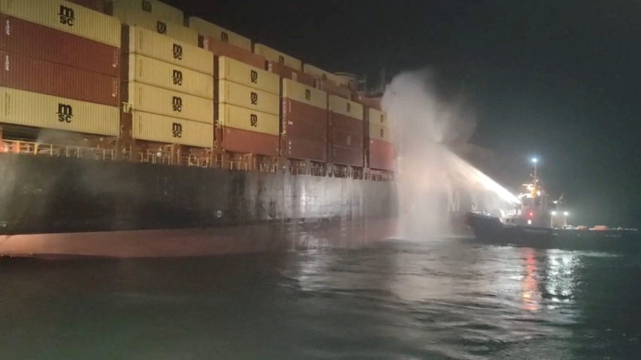 Personnel on a boat work to extinguish a fire on the Sariska V vessel in the Persian Gulf after MSC, the world's largest shipping group, said the vessel was struck by two projectiles in Iraq's Umm Qasr port, in this screengrab from a handout video released June 2, 2026.