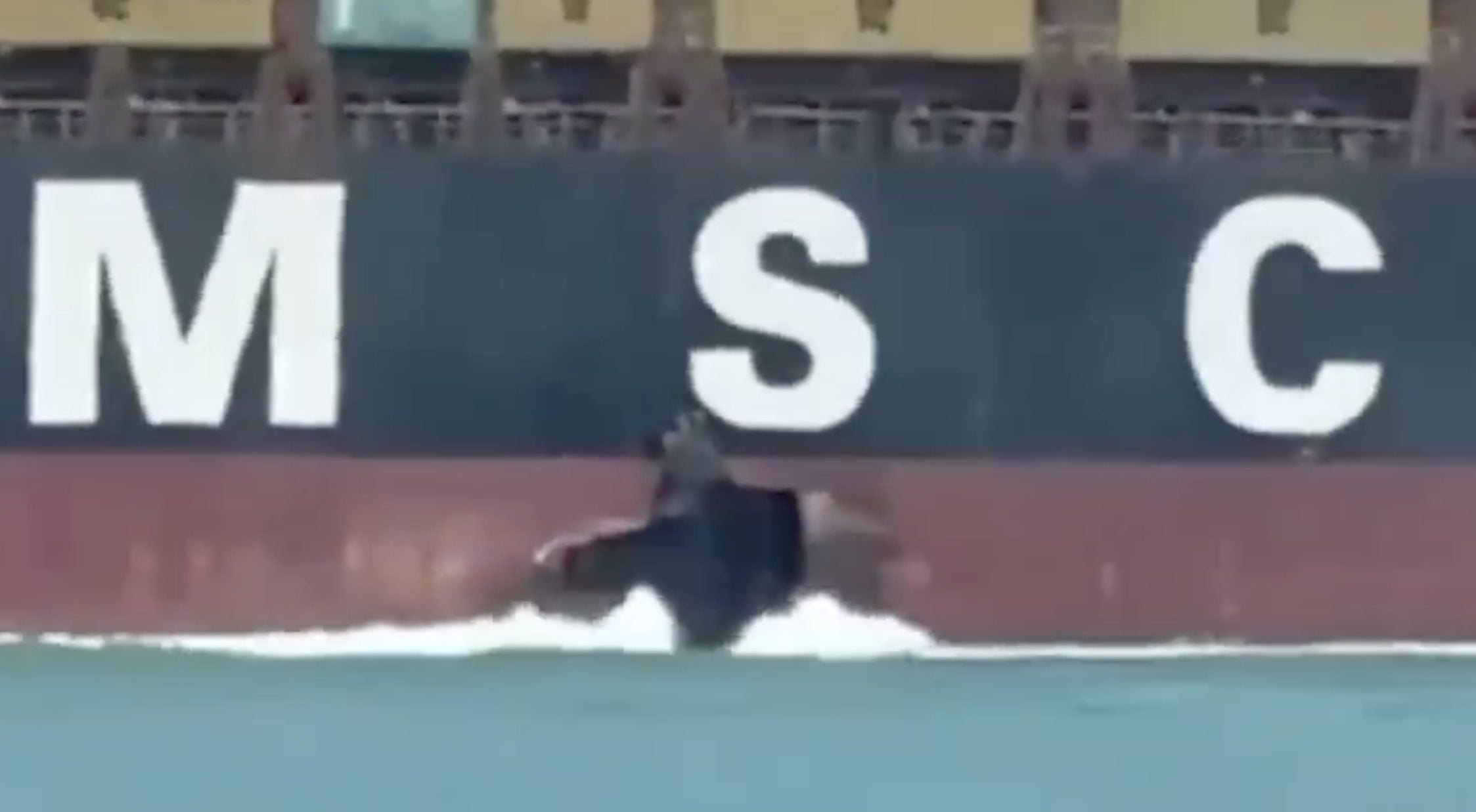 Screenshot from a circulating video showing hull damage above the waterline on the starboard side of the containership MSC Sariska V while underway in the Arabian Gulf.