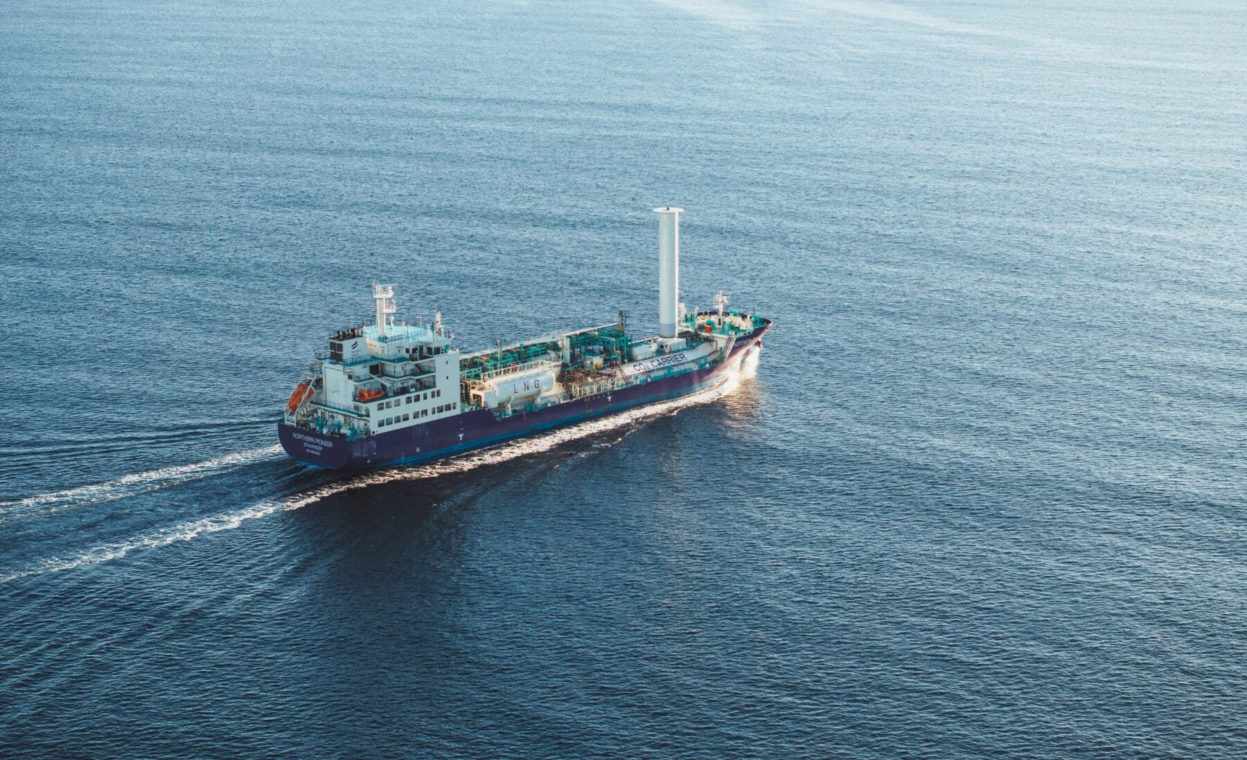 Aerial view of the liquefied CO? carrier Northern Pioneer sailing at sea. The blue-hulled vessel features a deck-mounted cargo system and rotor sail technology and is part of the Northern Lights carbon capture and storage transport fleet.