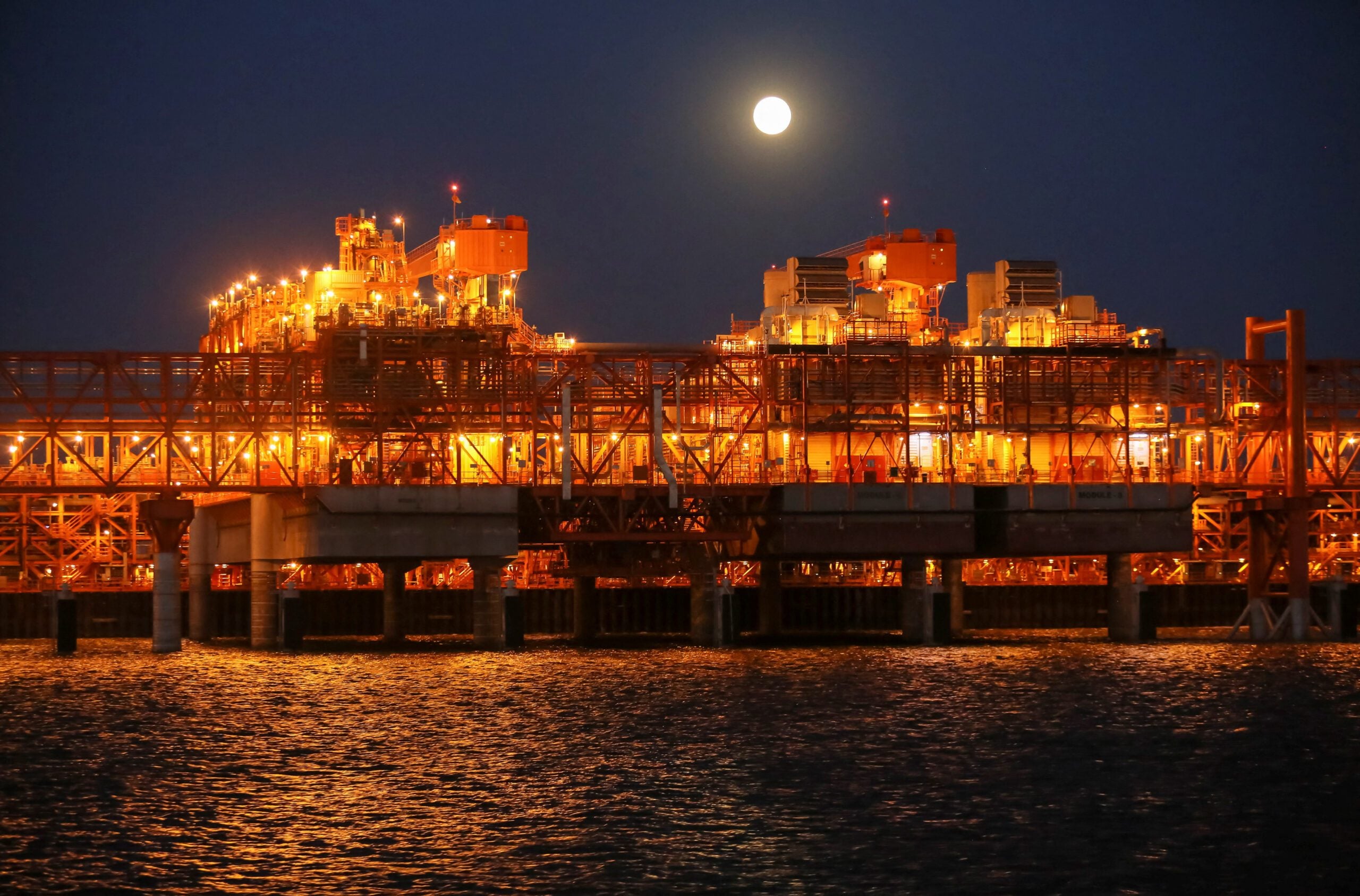 The full moon rises in the background over the infrastructure on D Island, the main processing hub, at the Kashagan offshore oil field in the Caspian sea in western Kazakhstan