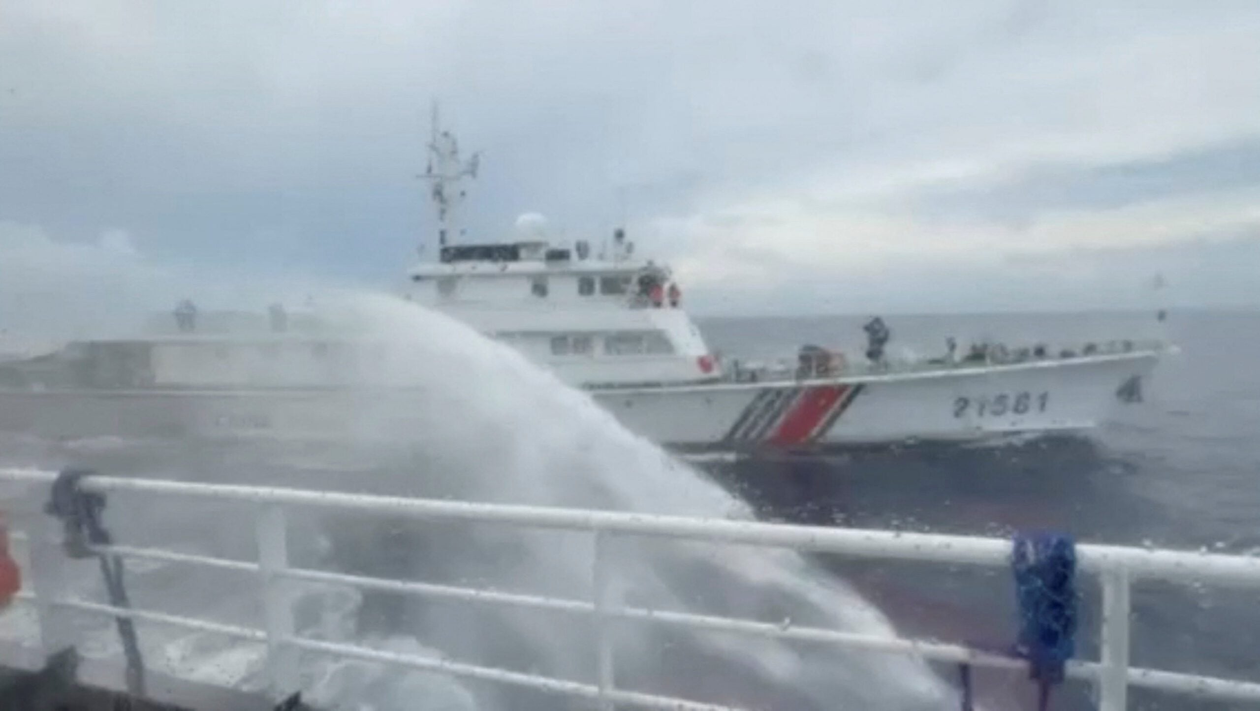 Water splashes onto a Philippine vessel after, according to the Philippine Coast Guard, a Chinese coast guard ship fired a water cannon