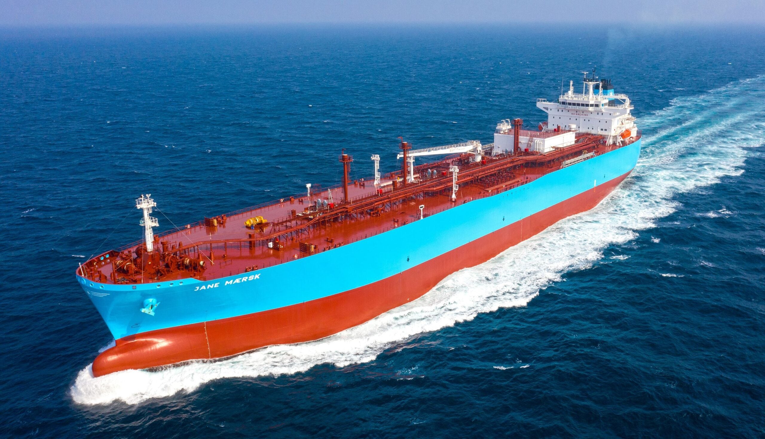 Aerial view of the Jane Maersk, a large blue-and-red Very Large Ammonia Carrier, sailing at sea after delivery from HD Hyundai Samho to Maersk.