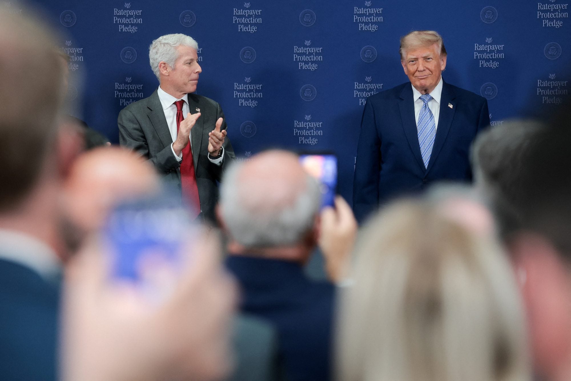 U.S. Energy Secretary Chris Wright applauds next to U.S. President Donald Trump at the Environmental Protection Agency (EPA) headquarters in Washington, D.C